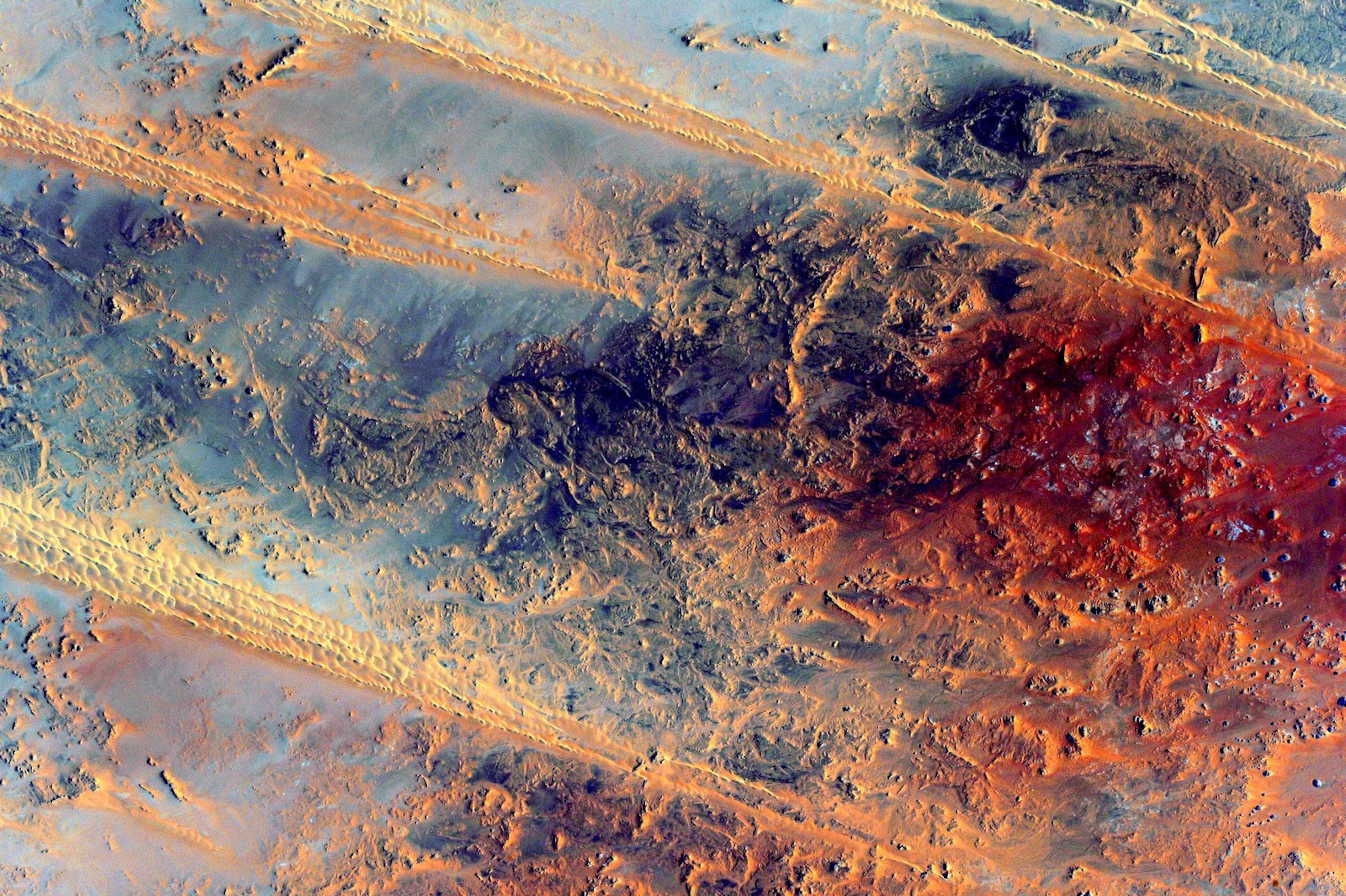 an aerial view of a beautiful blue and red landmass