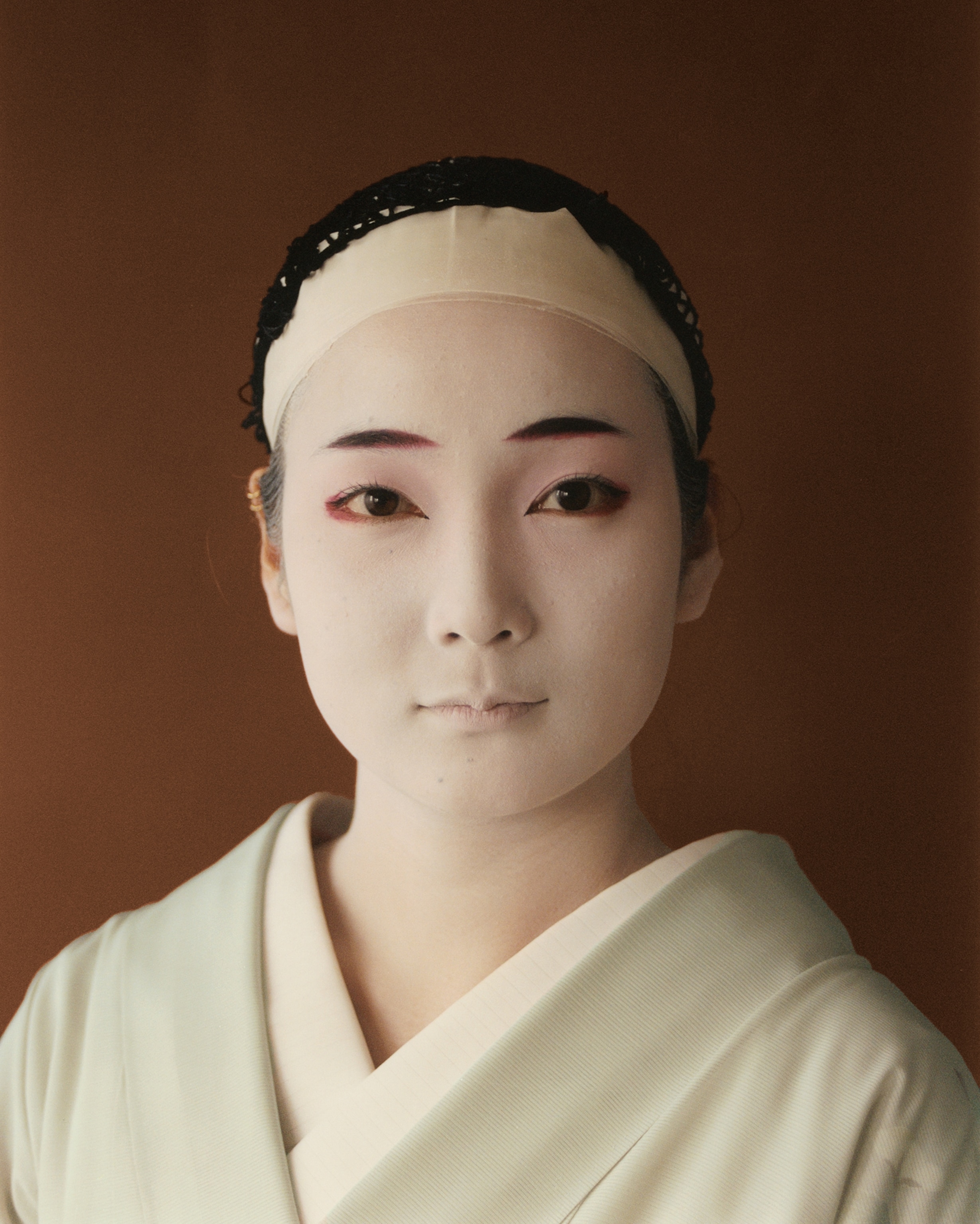 A portrait of Shichiha after applying oshiroi, the white makeup base used by geishas to create a smooth base that helps to highlight their features.