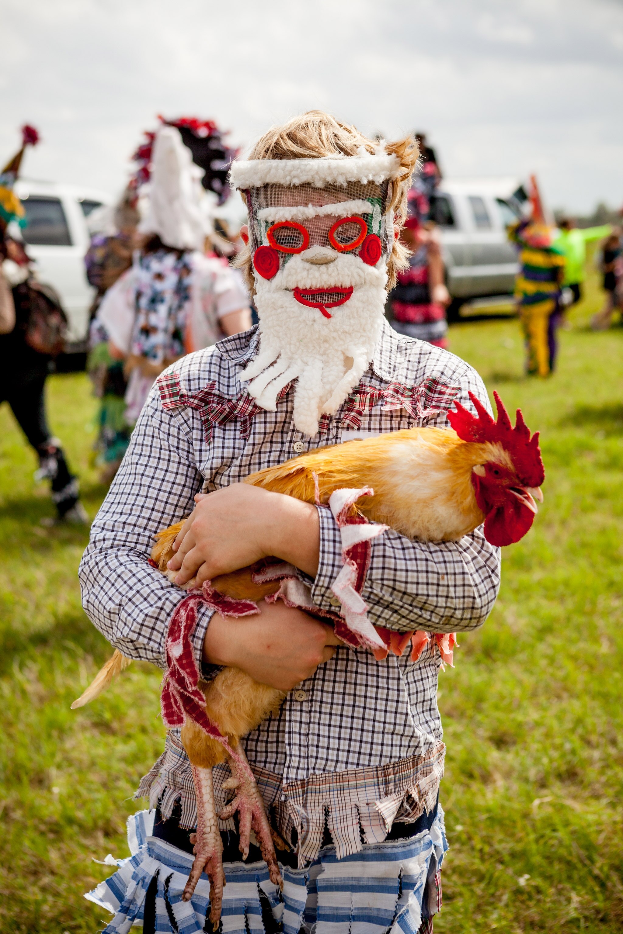 a person holding a chicken at the Courir de Mardi Gras celebration in Eunice, Louisiana