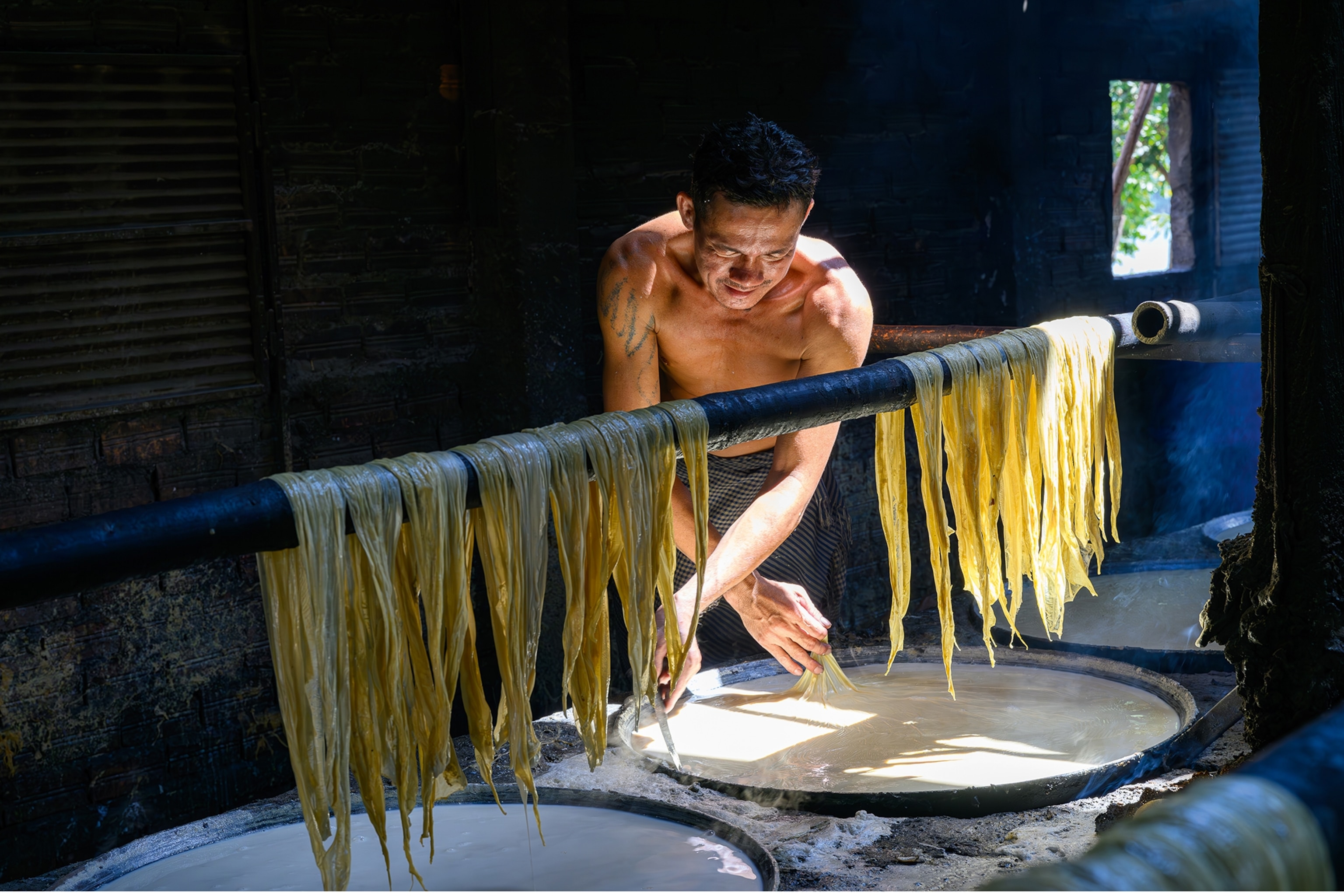 A local worker on Koh Dach Island, Cambodia drying bean curd skins.