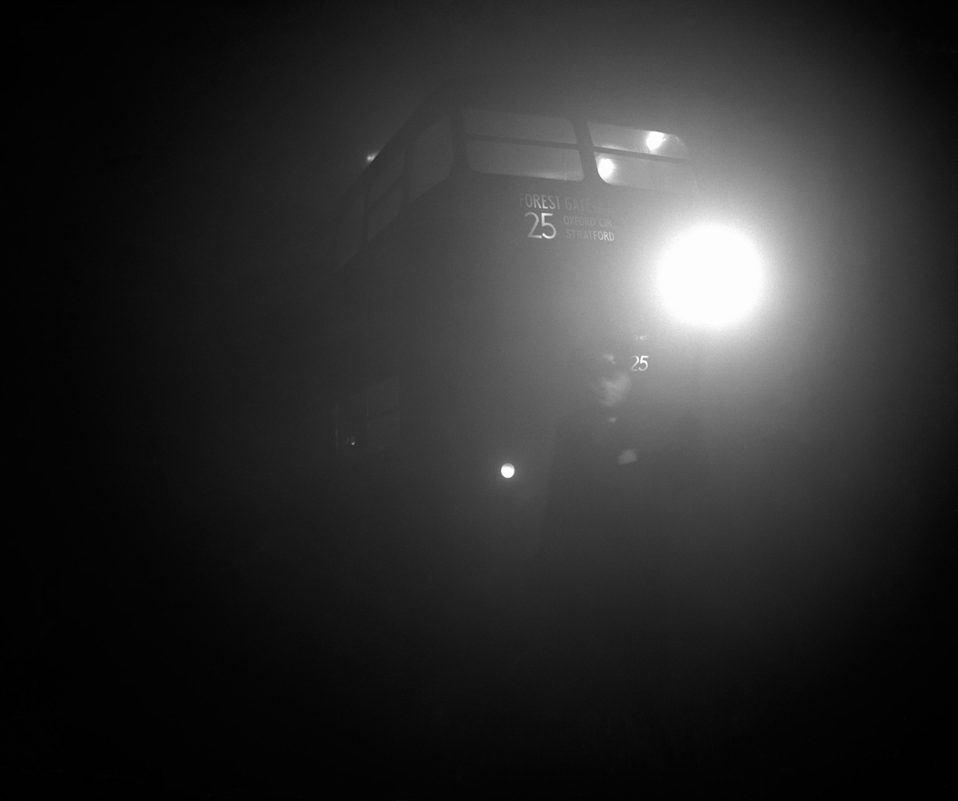 A London Transport inspector holding a flare leads a bus out of the terminus at Aldgate East as dense fog again blanketed London, causing widespread traffic chaos.