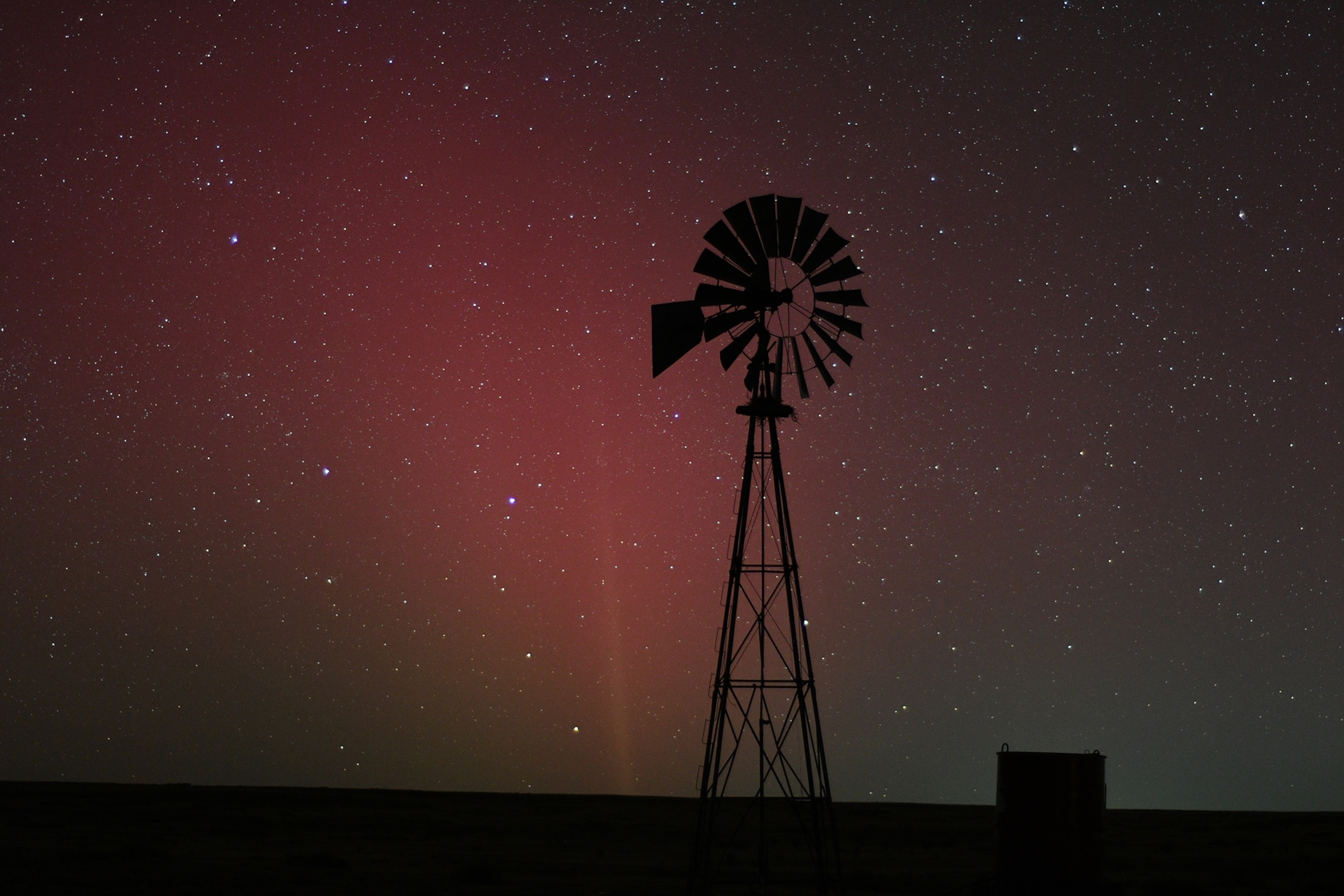 Image of a windmill with the Aurora across the night sky in Dalhart, Texas.