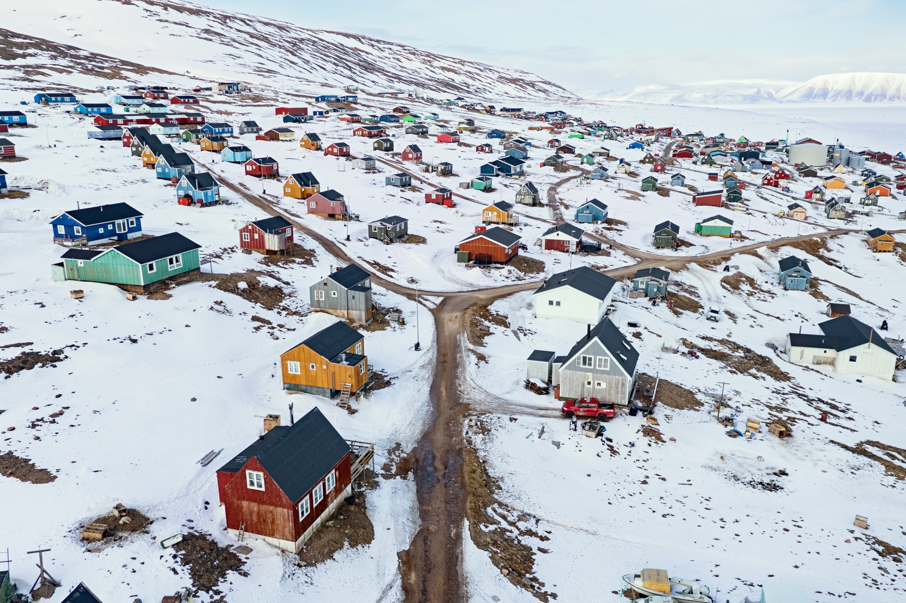 colorful houses on a snowy hill with dirt roads