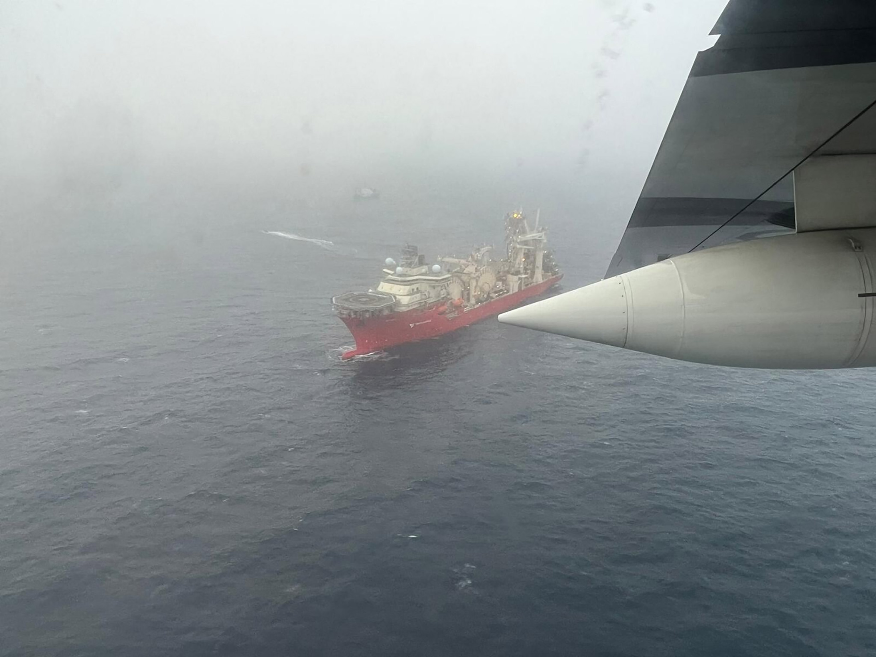 A ship in water take from above, with foggy weather.