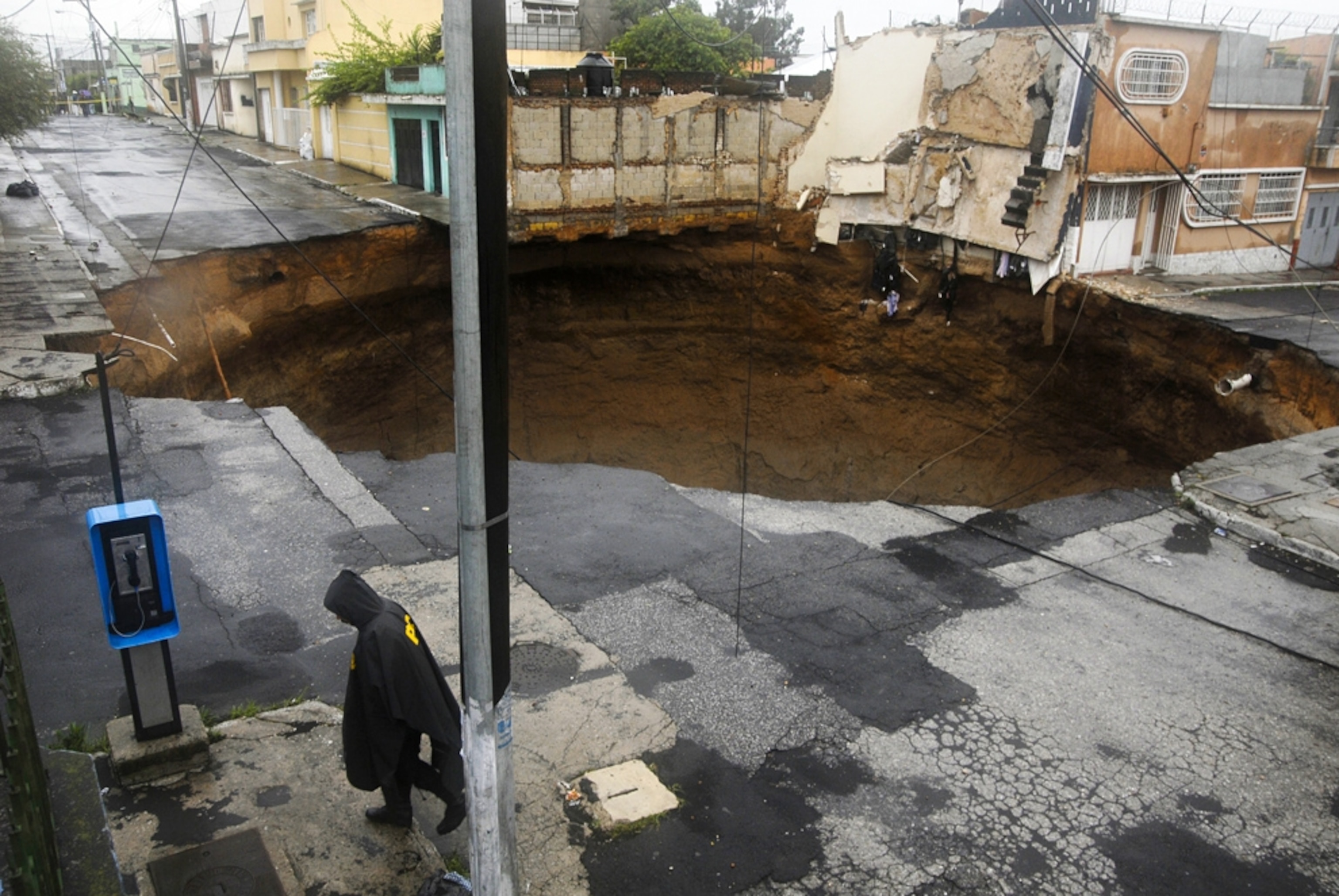 a police officer walking near a sinkhole in Guatemala, 2010.