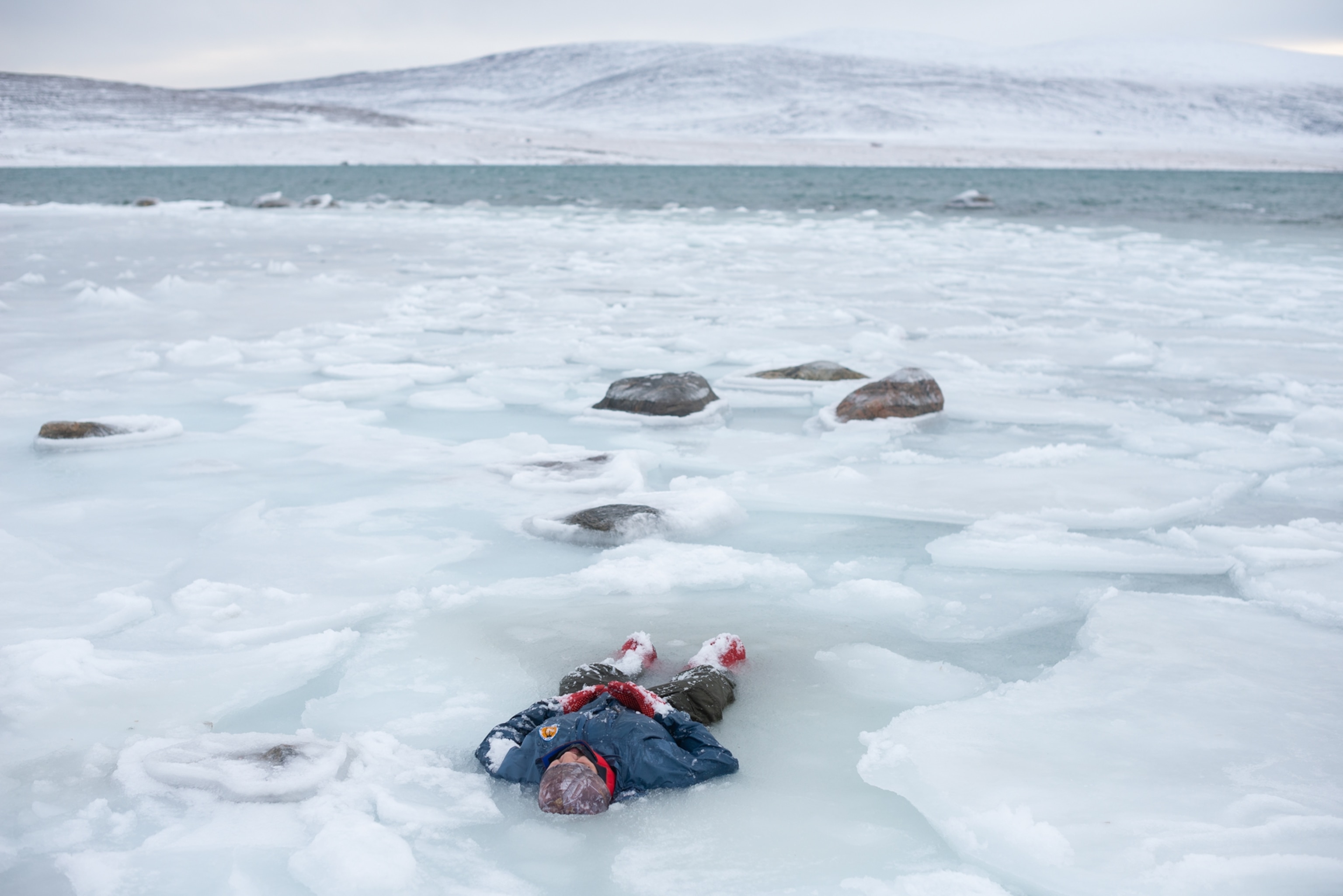 a person lying in a pool of icy slush and water