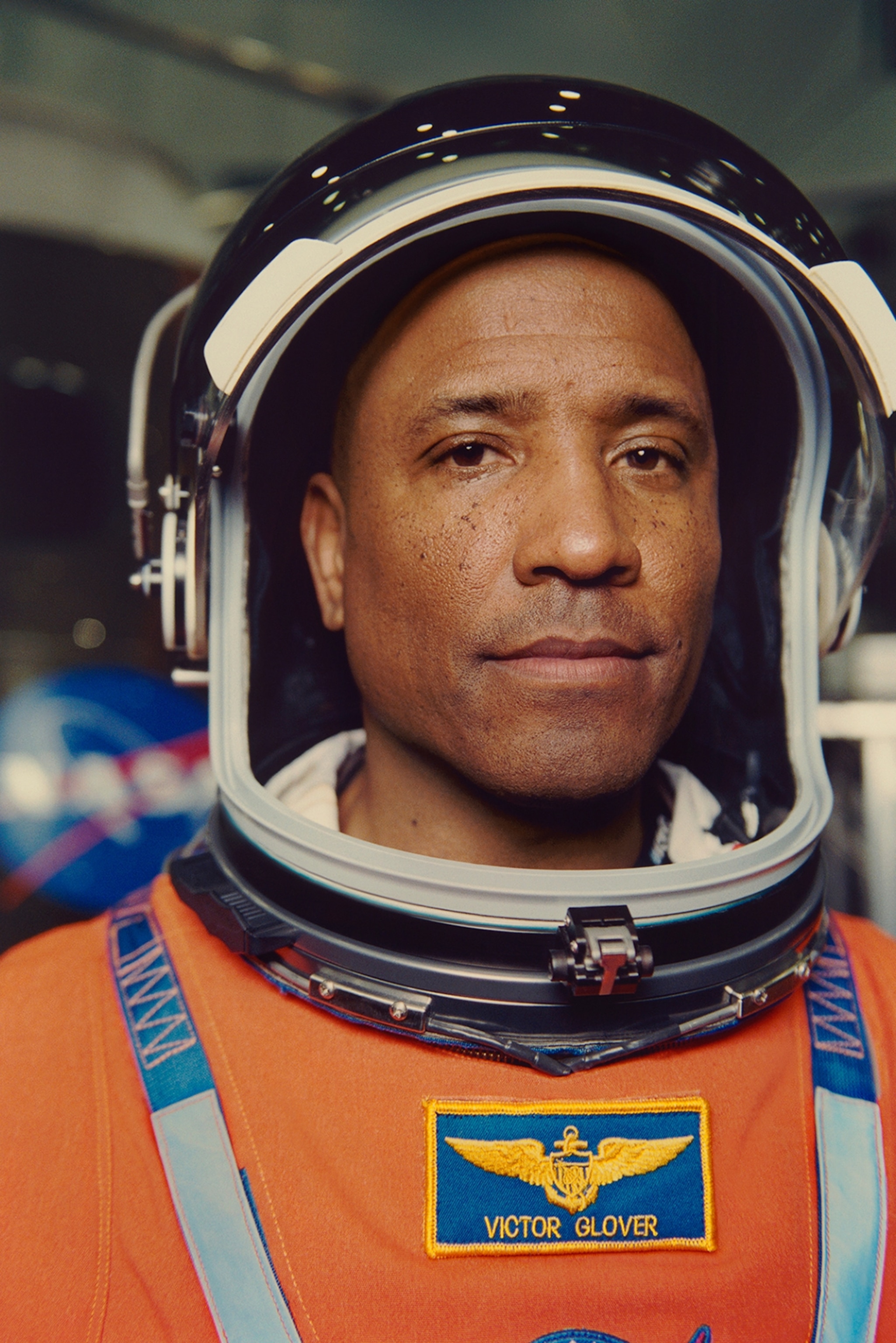 A portrait of a man in an orange astronaut suit