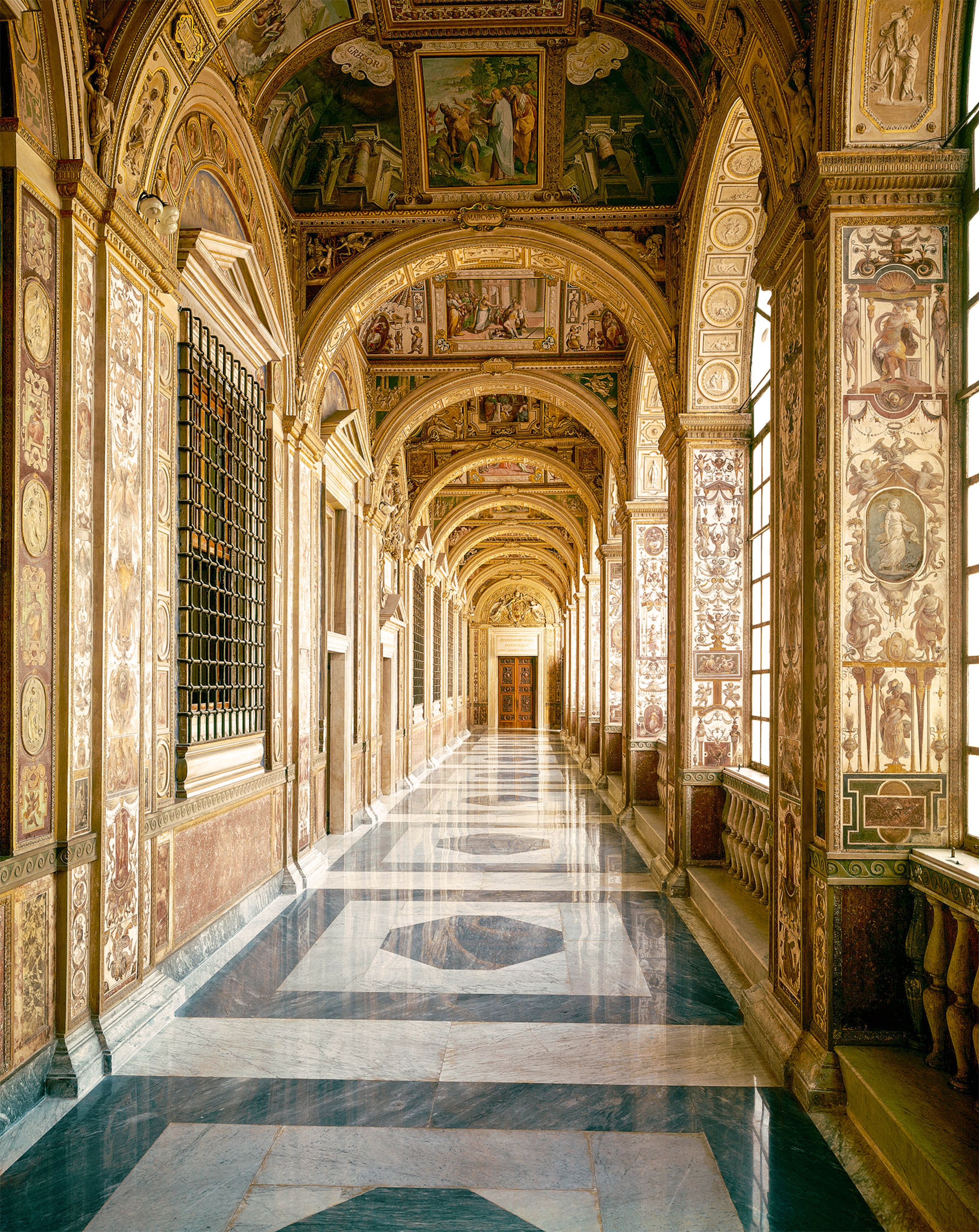 A view of the extravagant Gallery of Maps in the Borgia Apartment, including paintings and carvings and gold adorning the walls and ceilings
