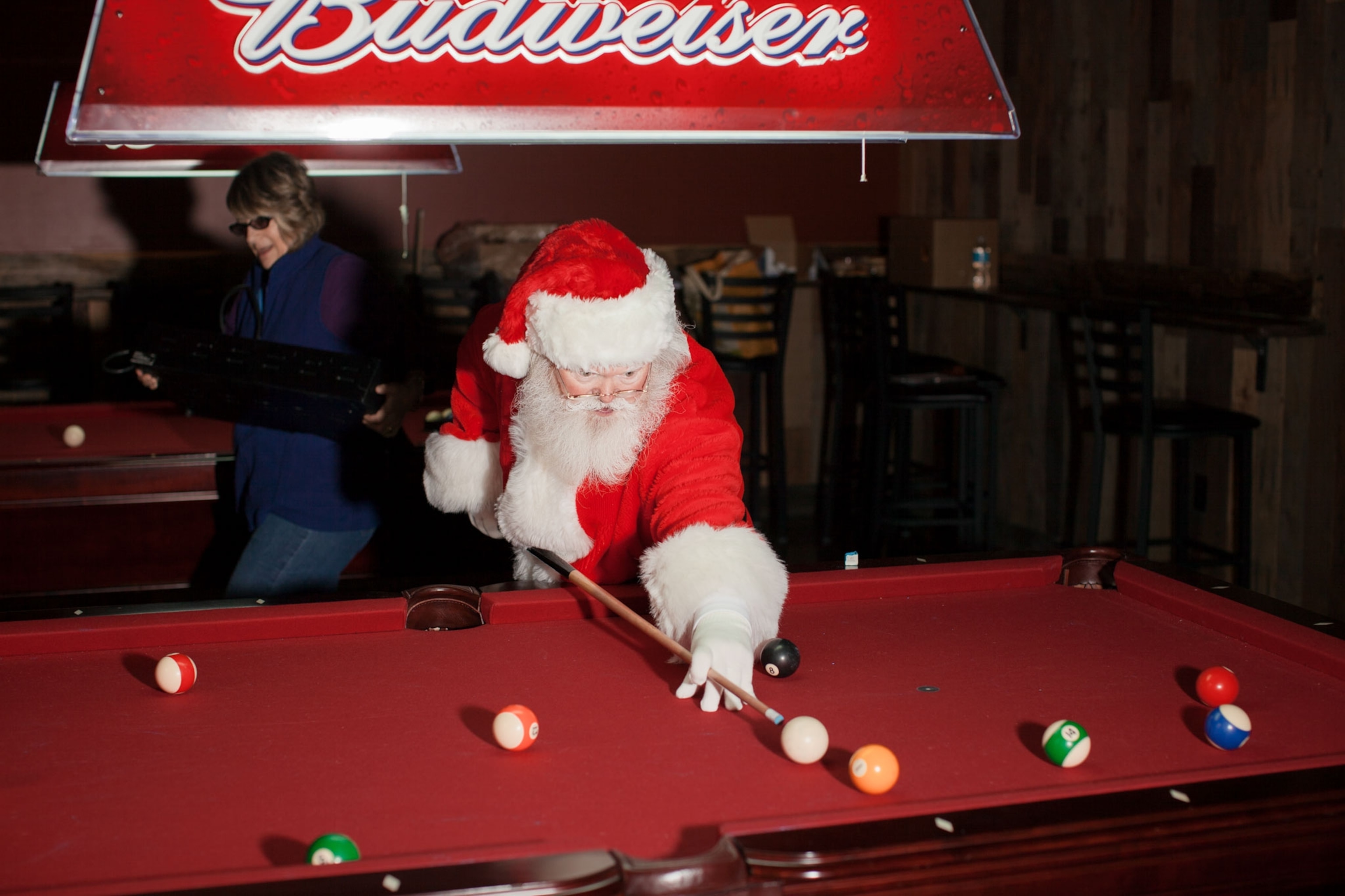 a person dressed as Santa playing billiards