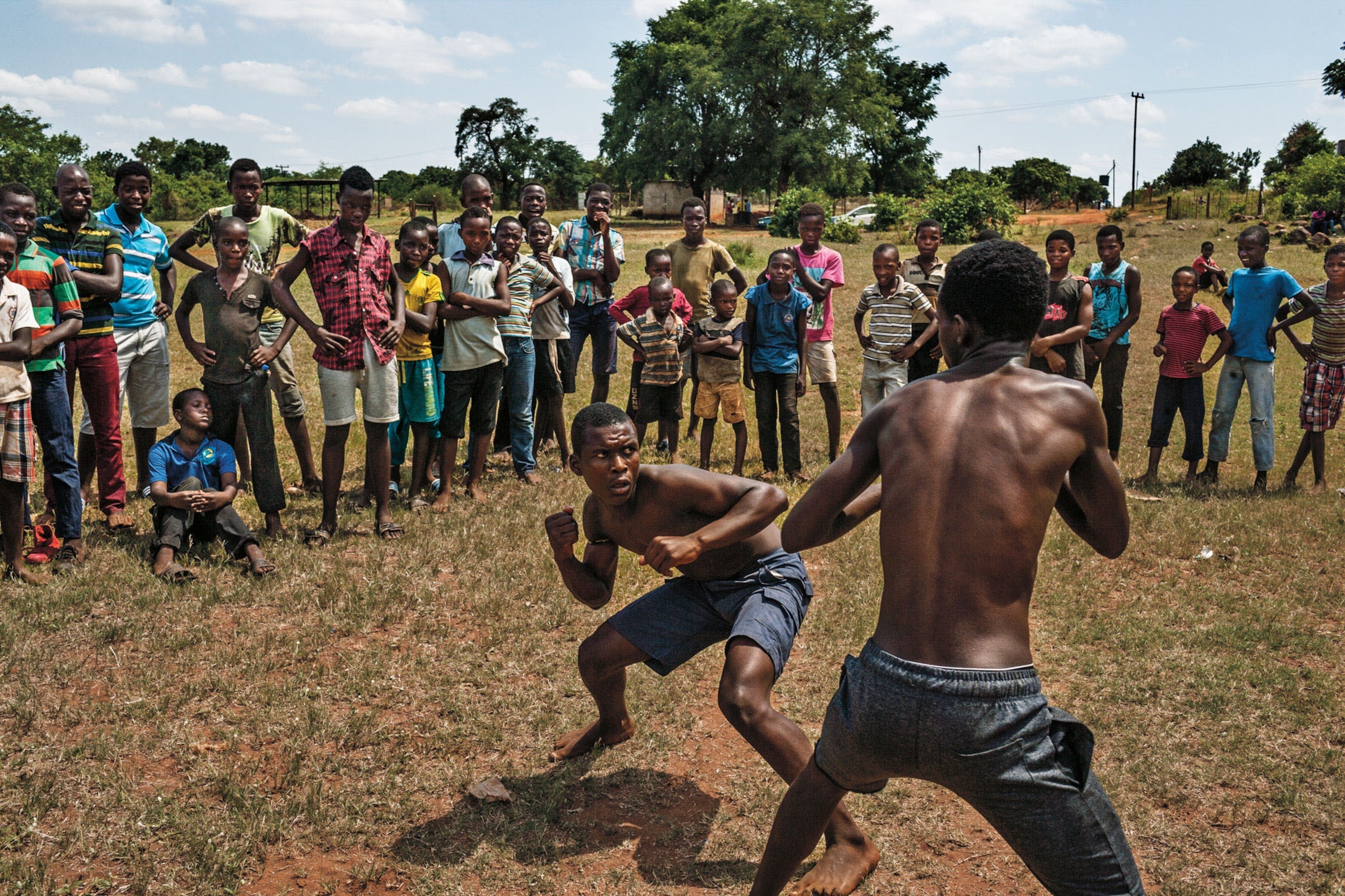 two boys boxing in front of spectators
