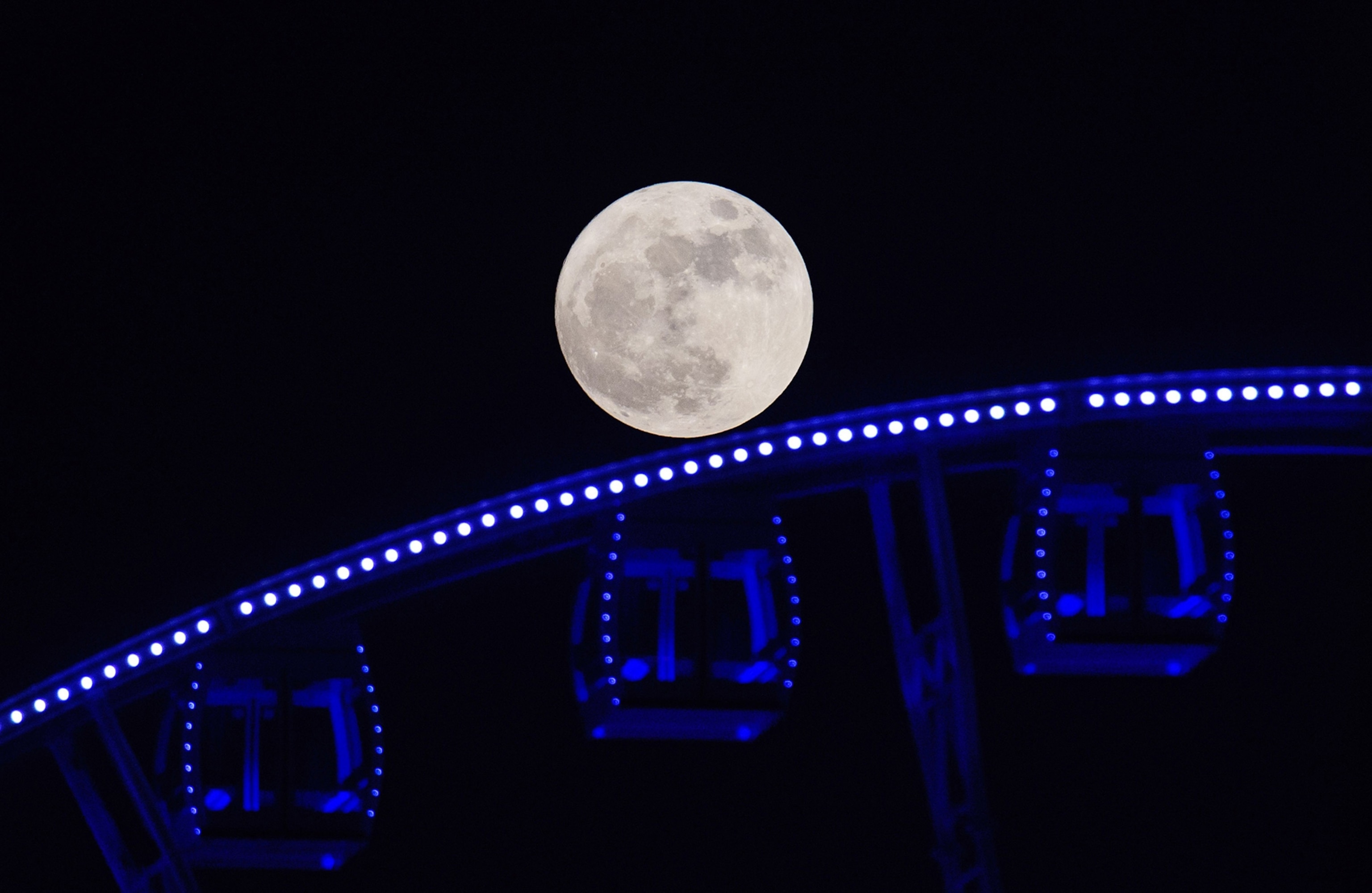 supermoon is seen rising beyond a ferris wheel in Hong Kong