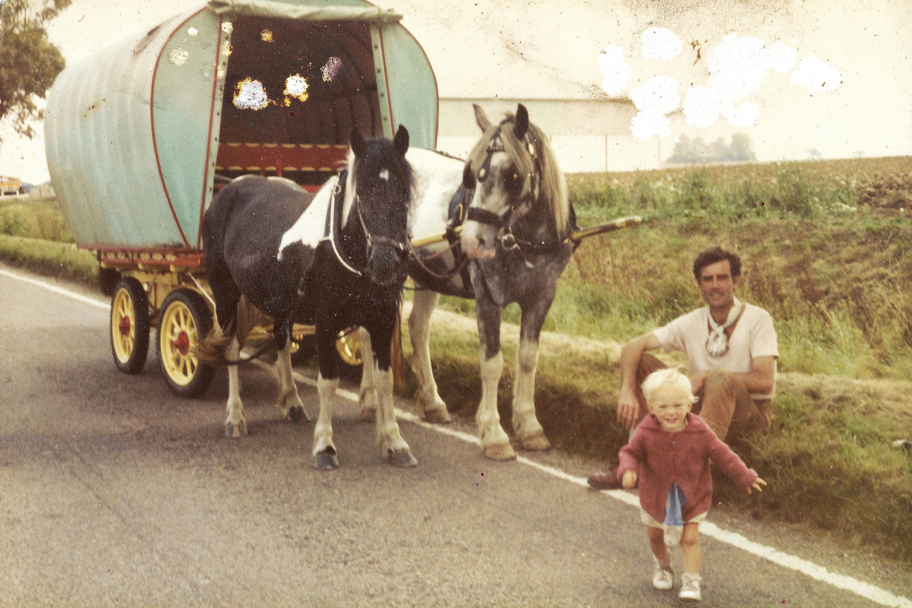 Picture of man with child on the road with a waggon pulled by horses