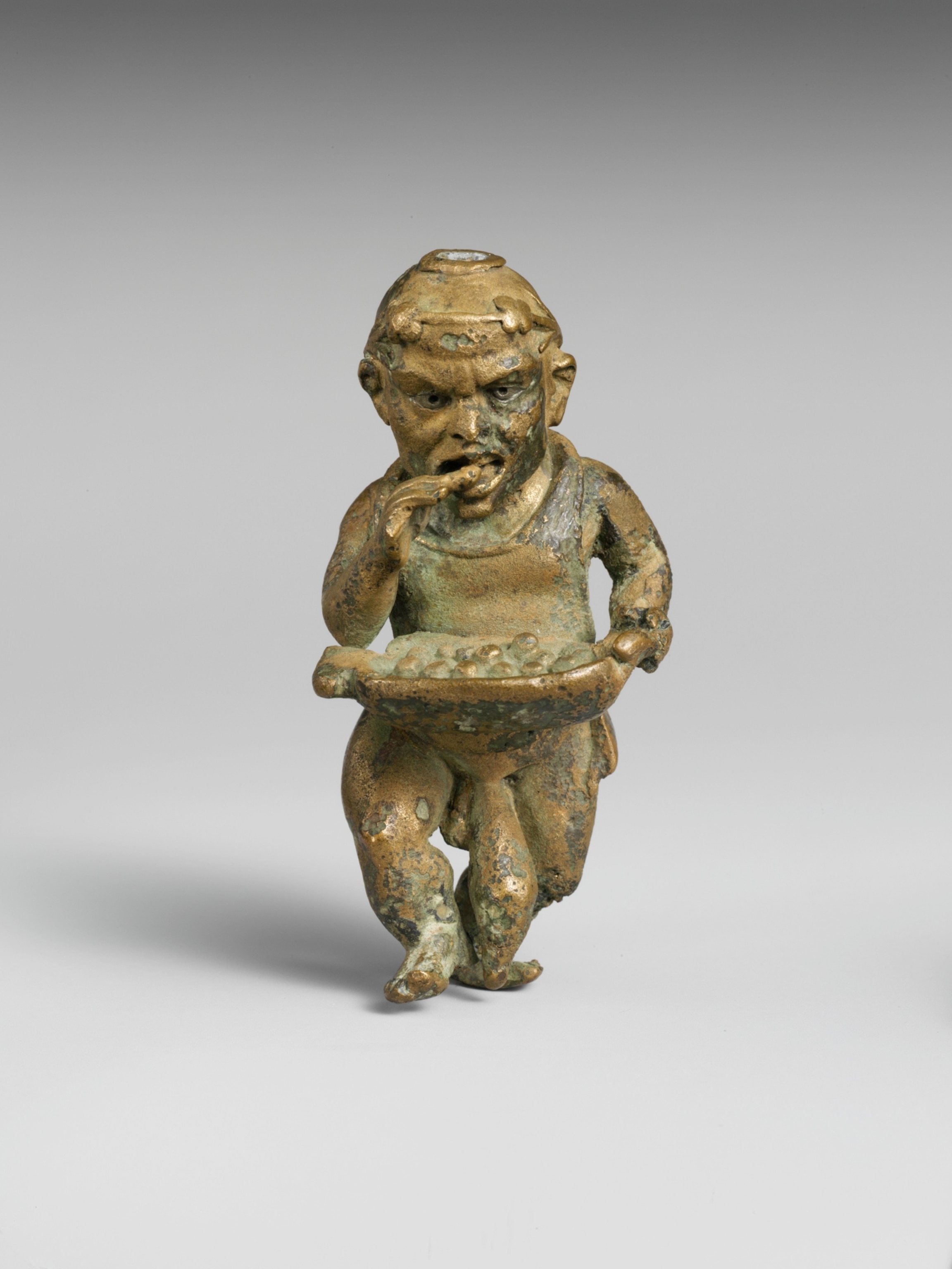 A statue of a man with container depicting him walking and eating at the same time.