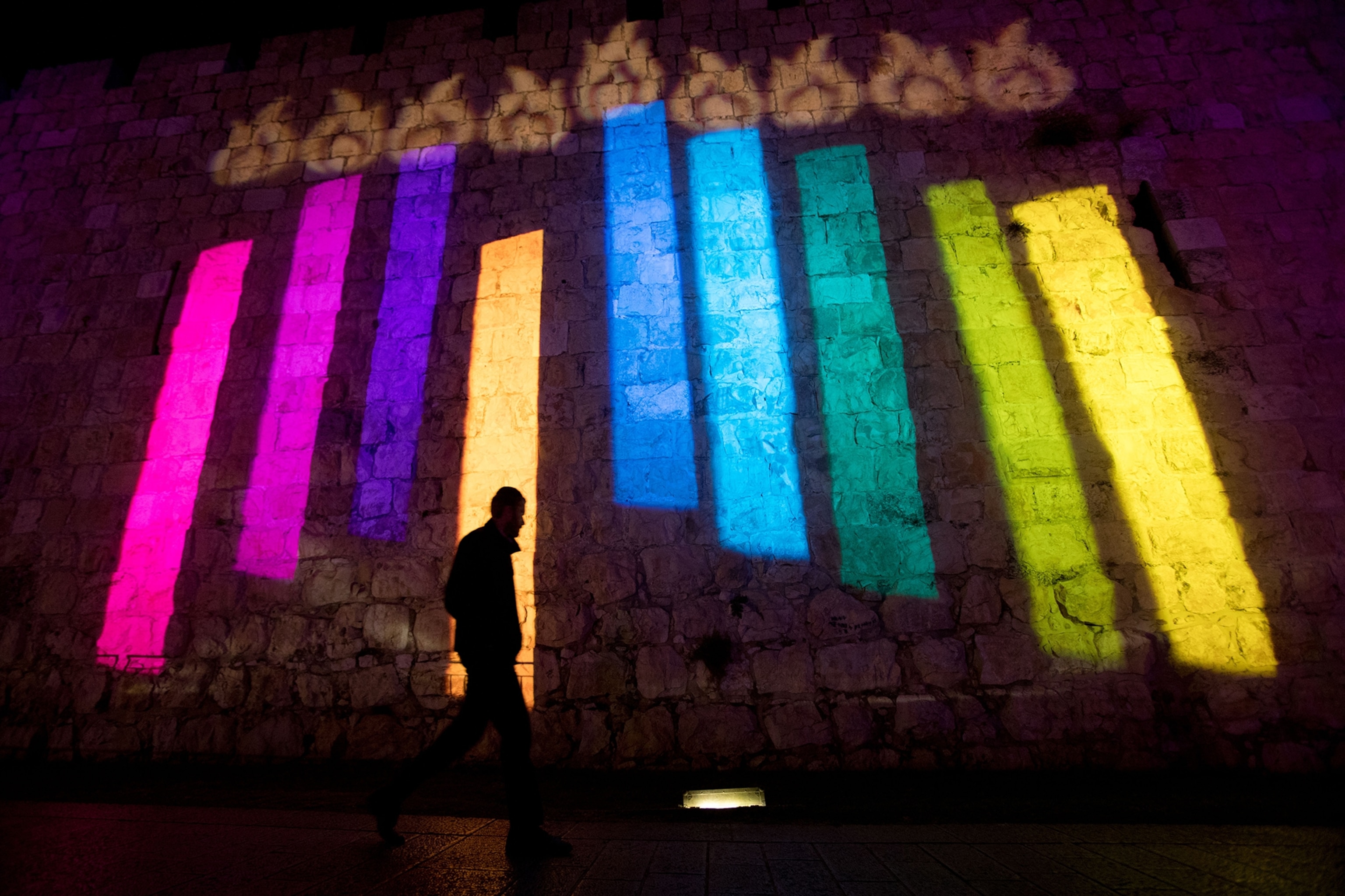 people walking past the walls of Jerusalem