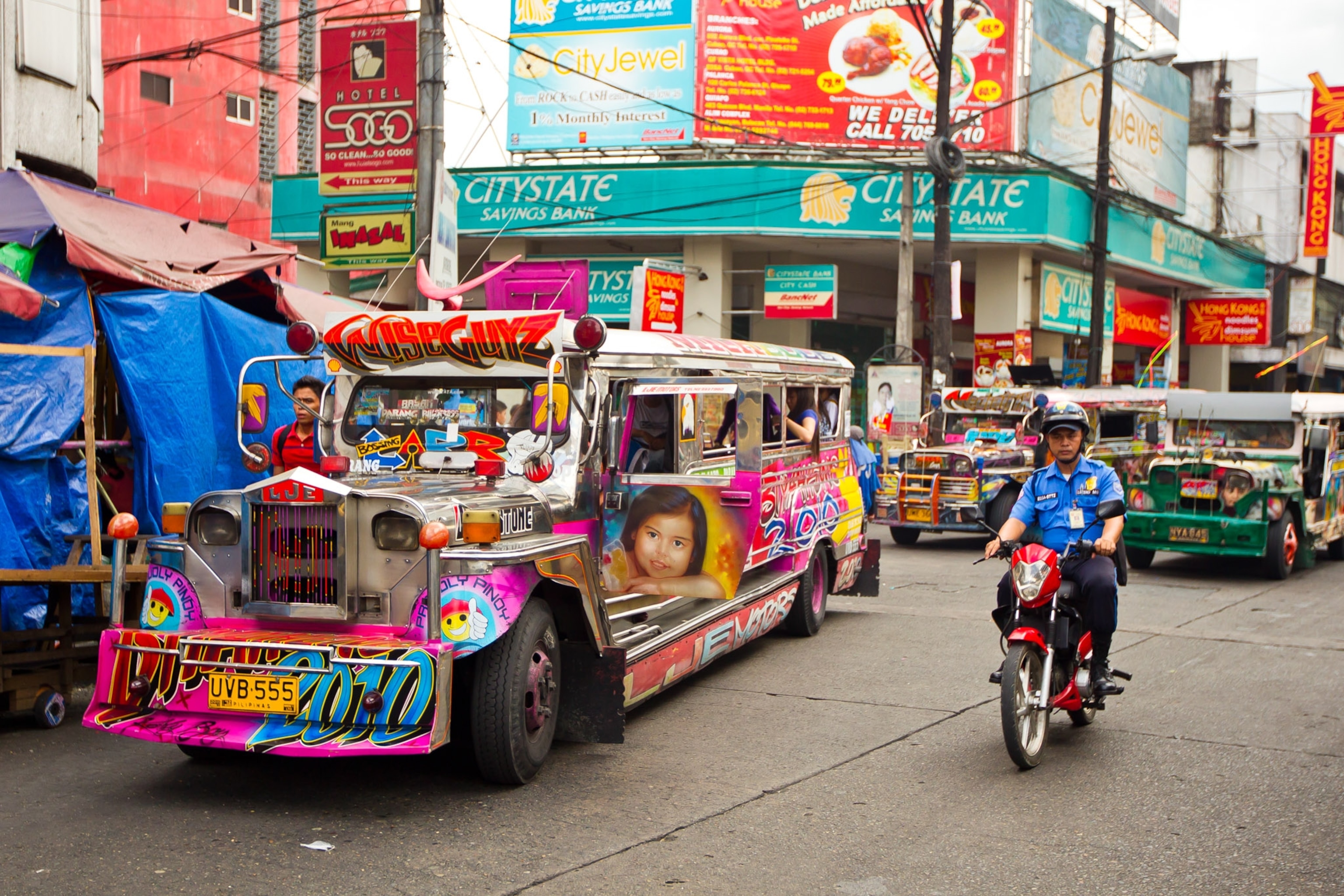 A colorful bus with pictures in a busy city.