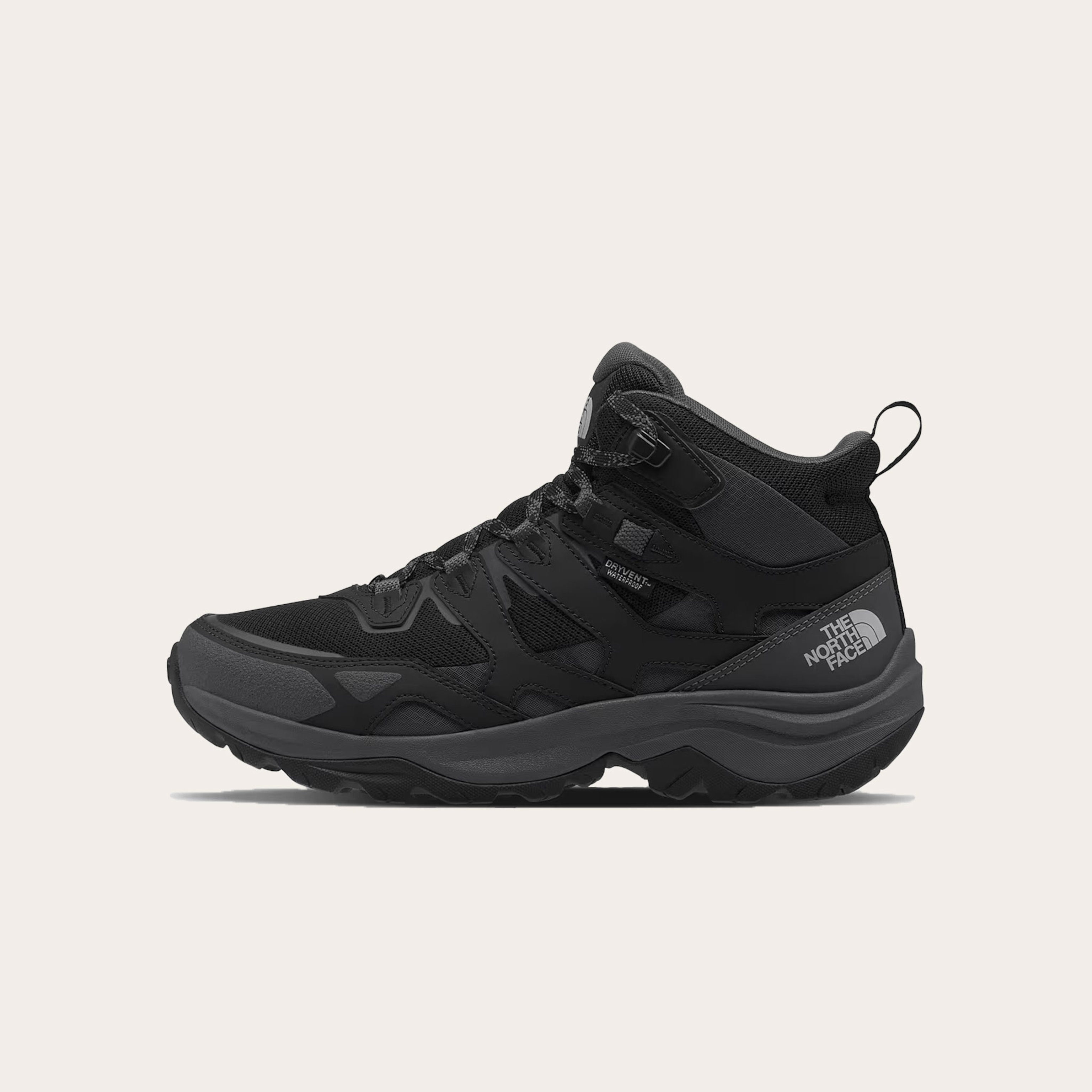Black and dark grey hiking boots placed on a tan background.