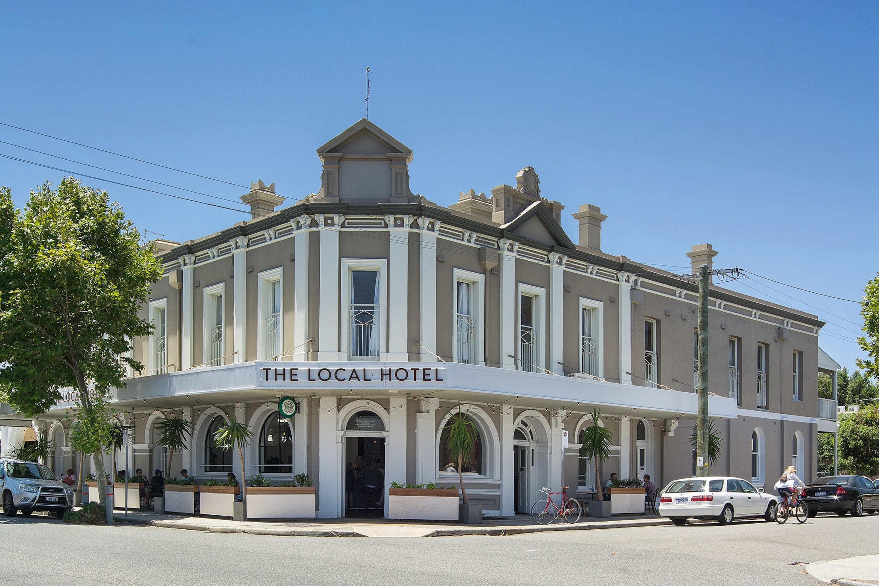 Exterior of a building on a street corner with 'The Local Hotel' on the front signage