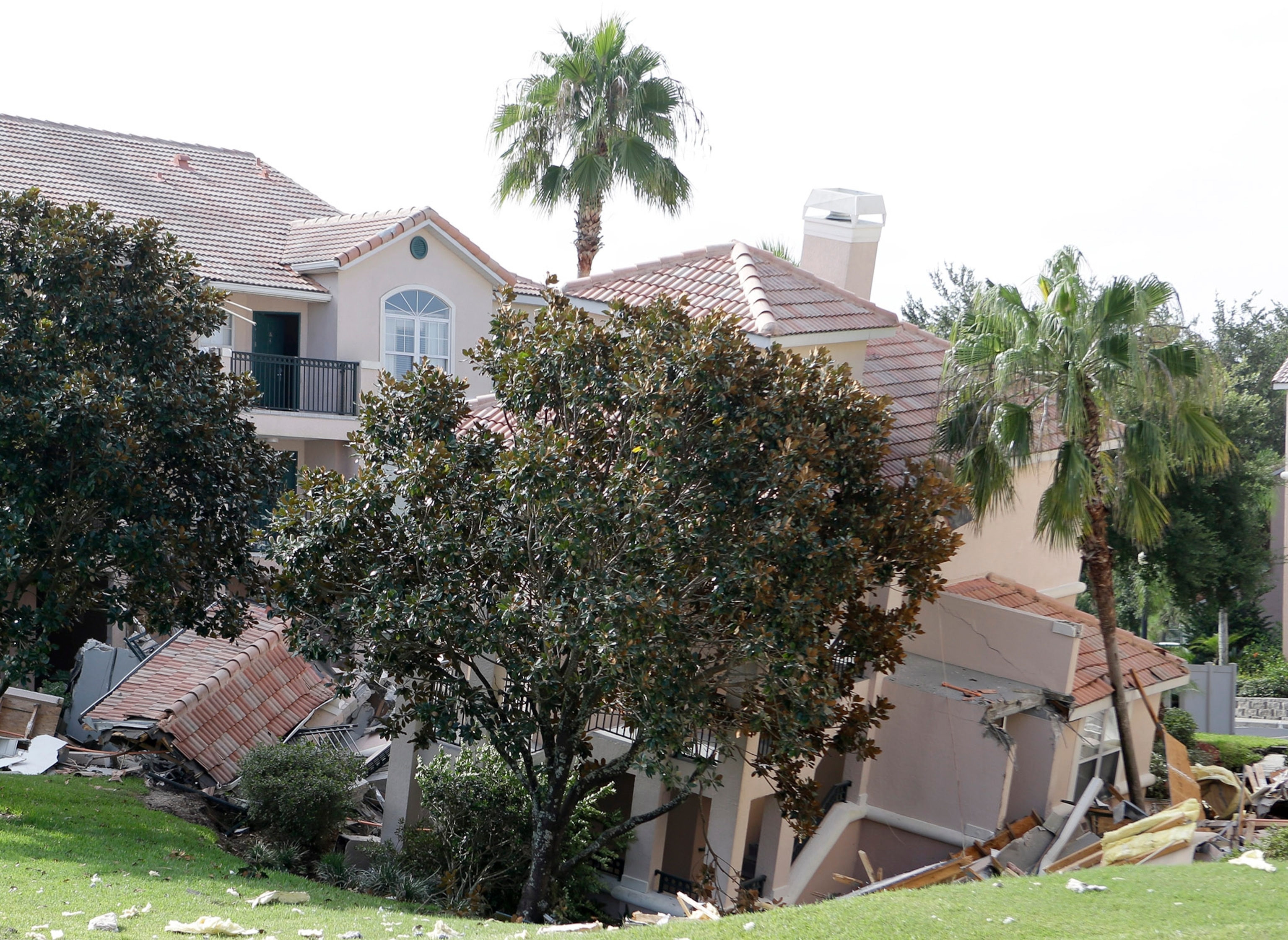 Kim Russell, left, who lives nearby on Gilbralter Street and her mother Betty Box both examine the massive sinkhole that opened on Eldridge Road in Spring Hill, Fla., Saturday. T