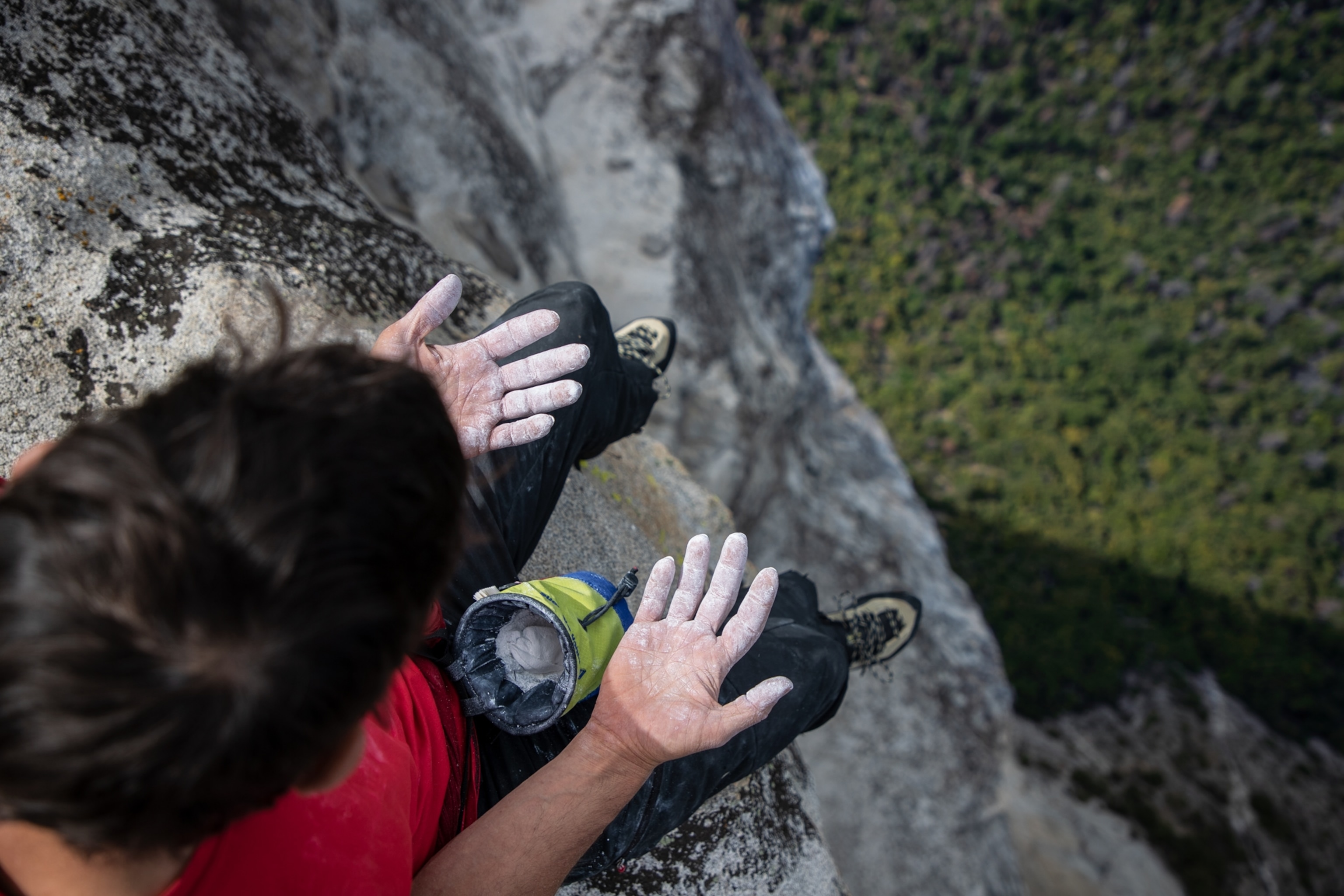 man on the top of the mountain looking onto his hands