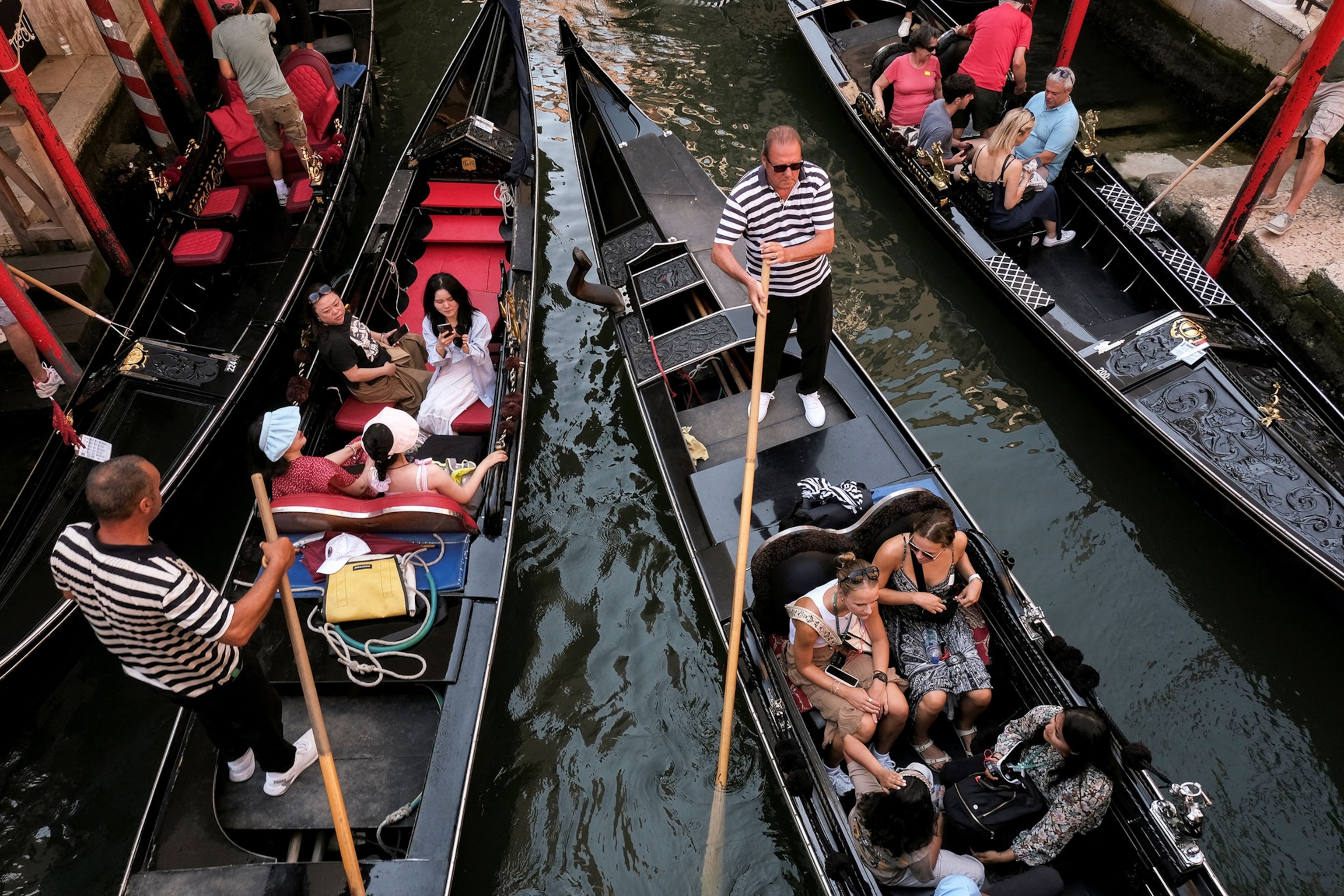 Day-trippers take a gondola tour in the canals of Venice