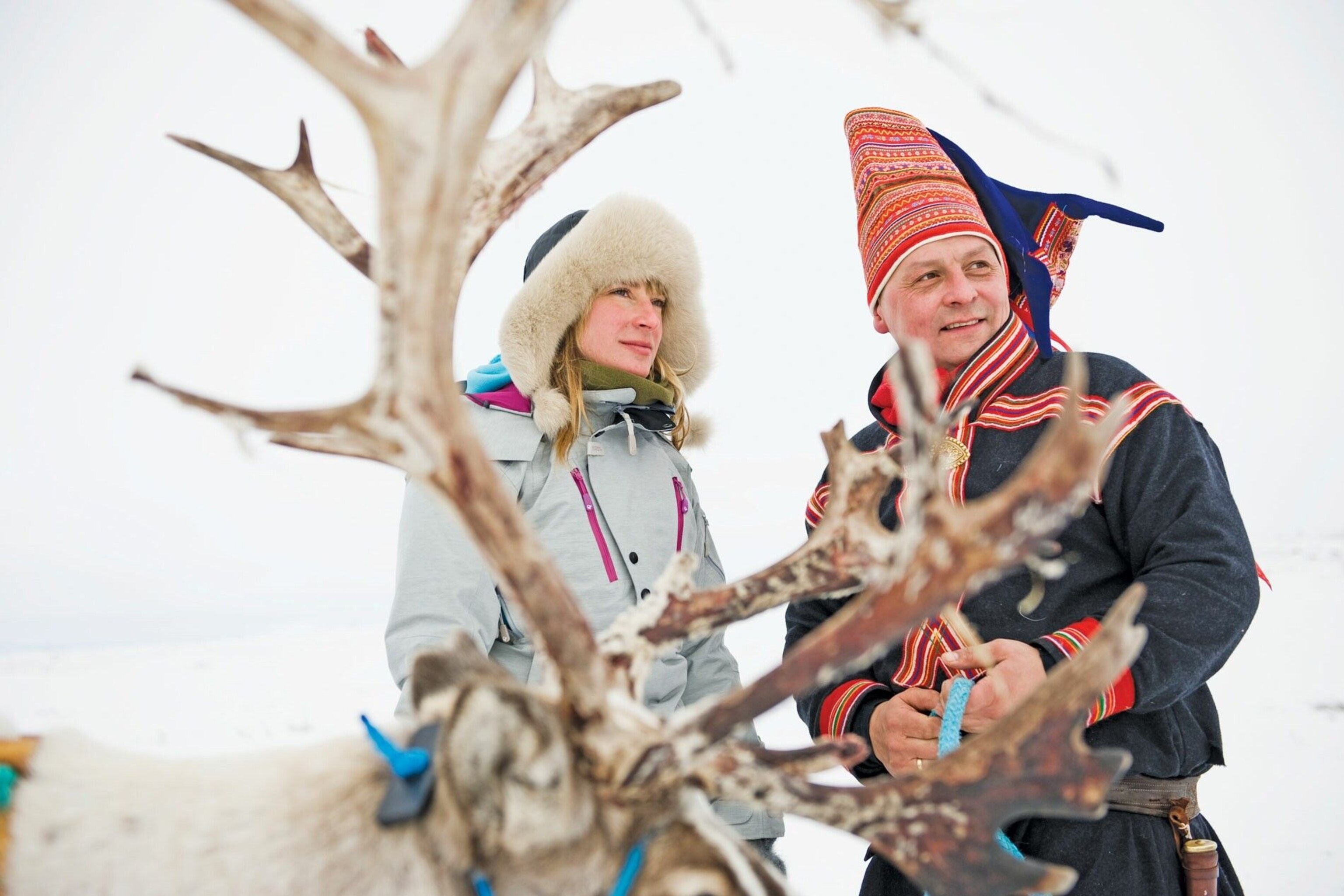 A reindeer and two people.