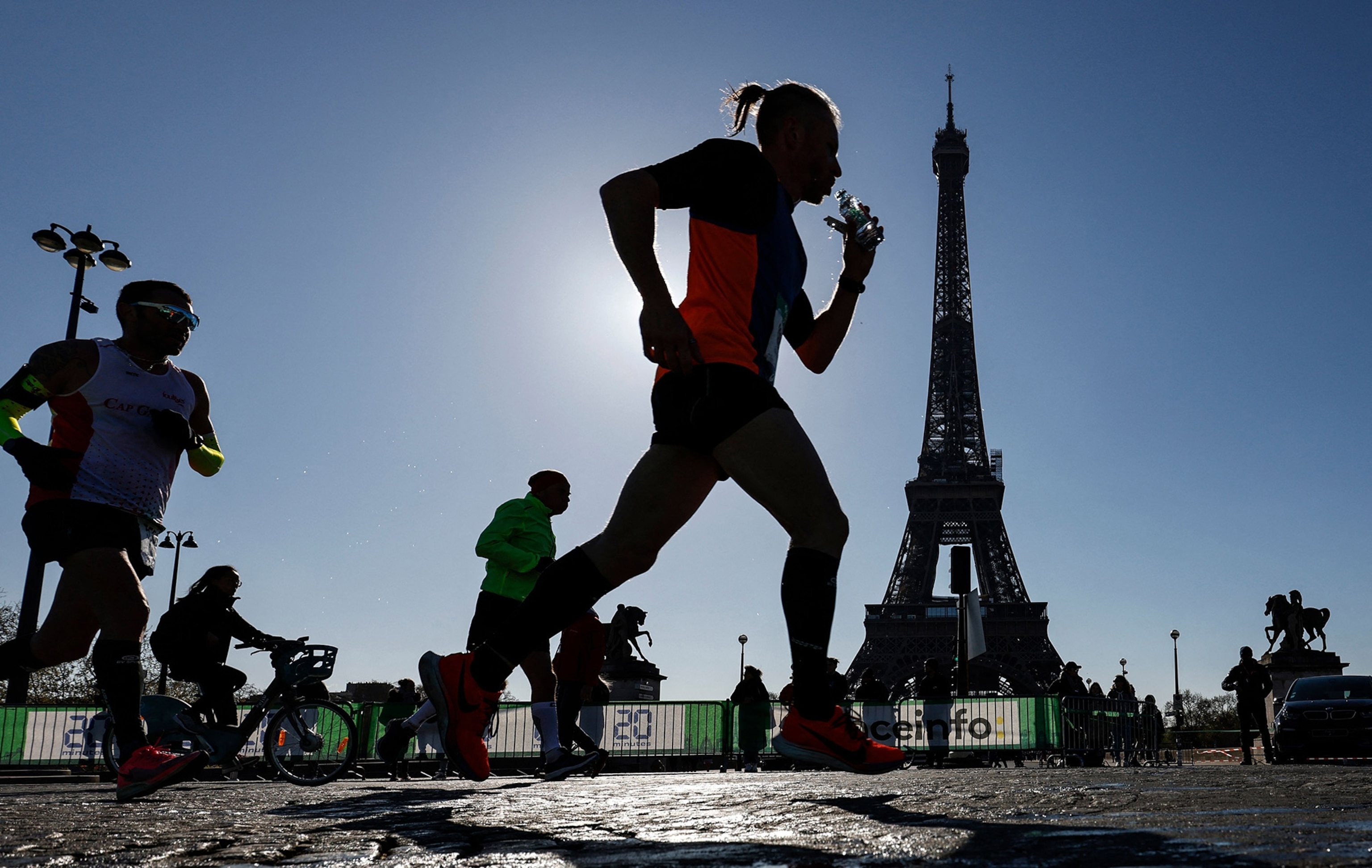 Silhouettes of runners pass in front of the Eiffel Tower during the 45th edition of the Paris Marathon