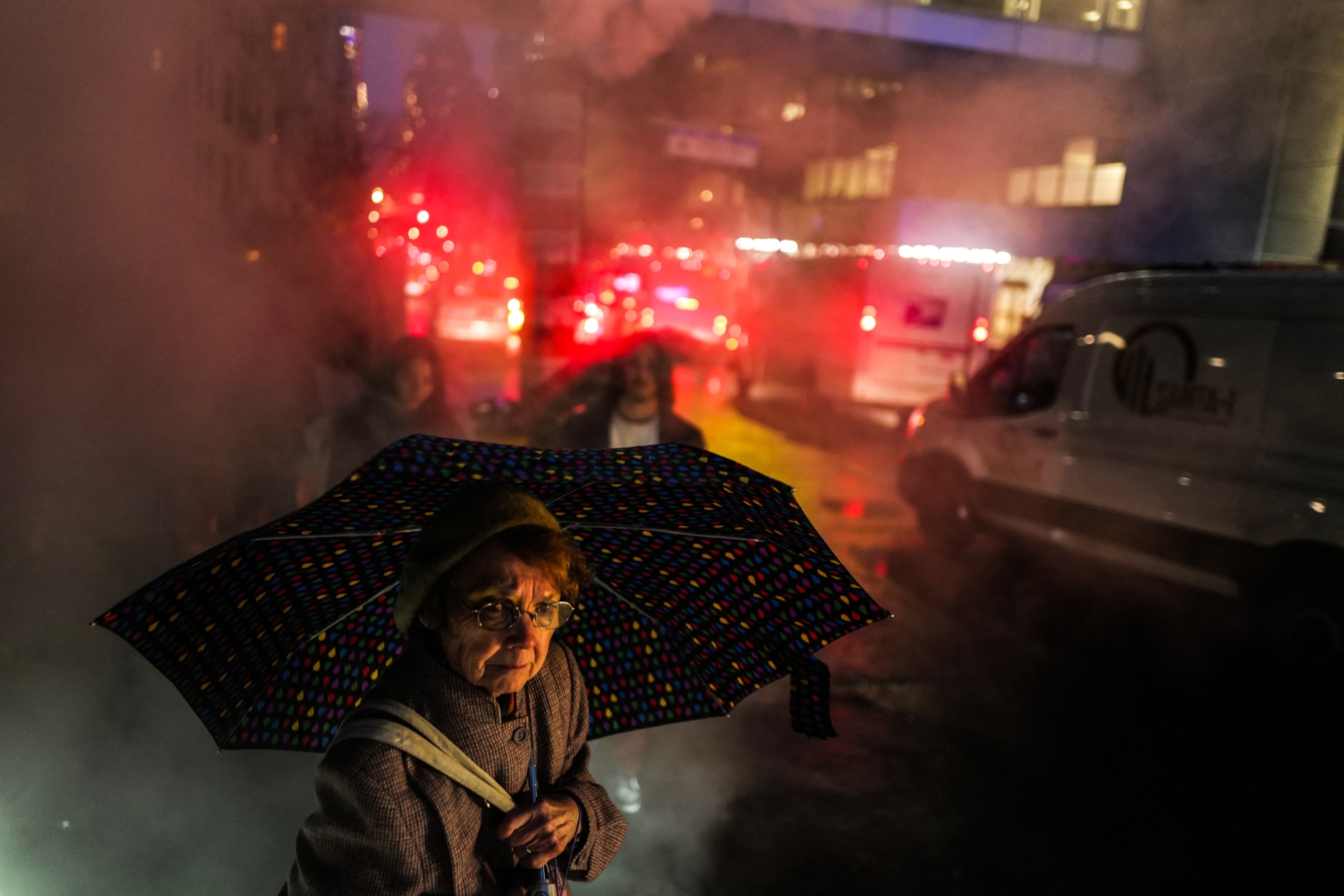 a woman holding an umbrella walking through a city