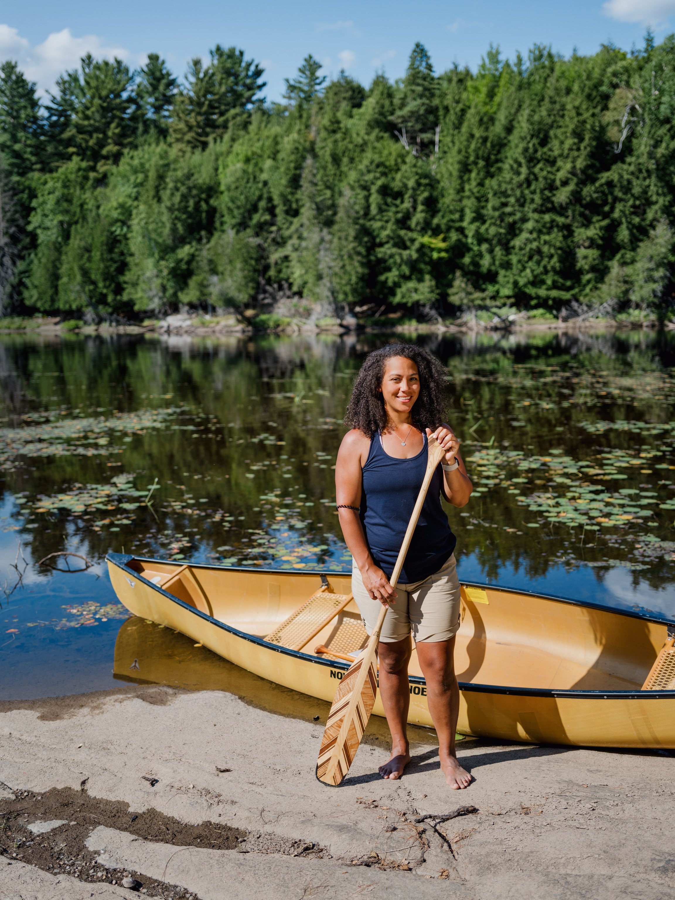Tori Baird stands with a custom-made paddle next to her canoe along the Magnetawan River.