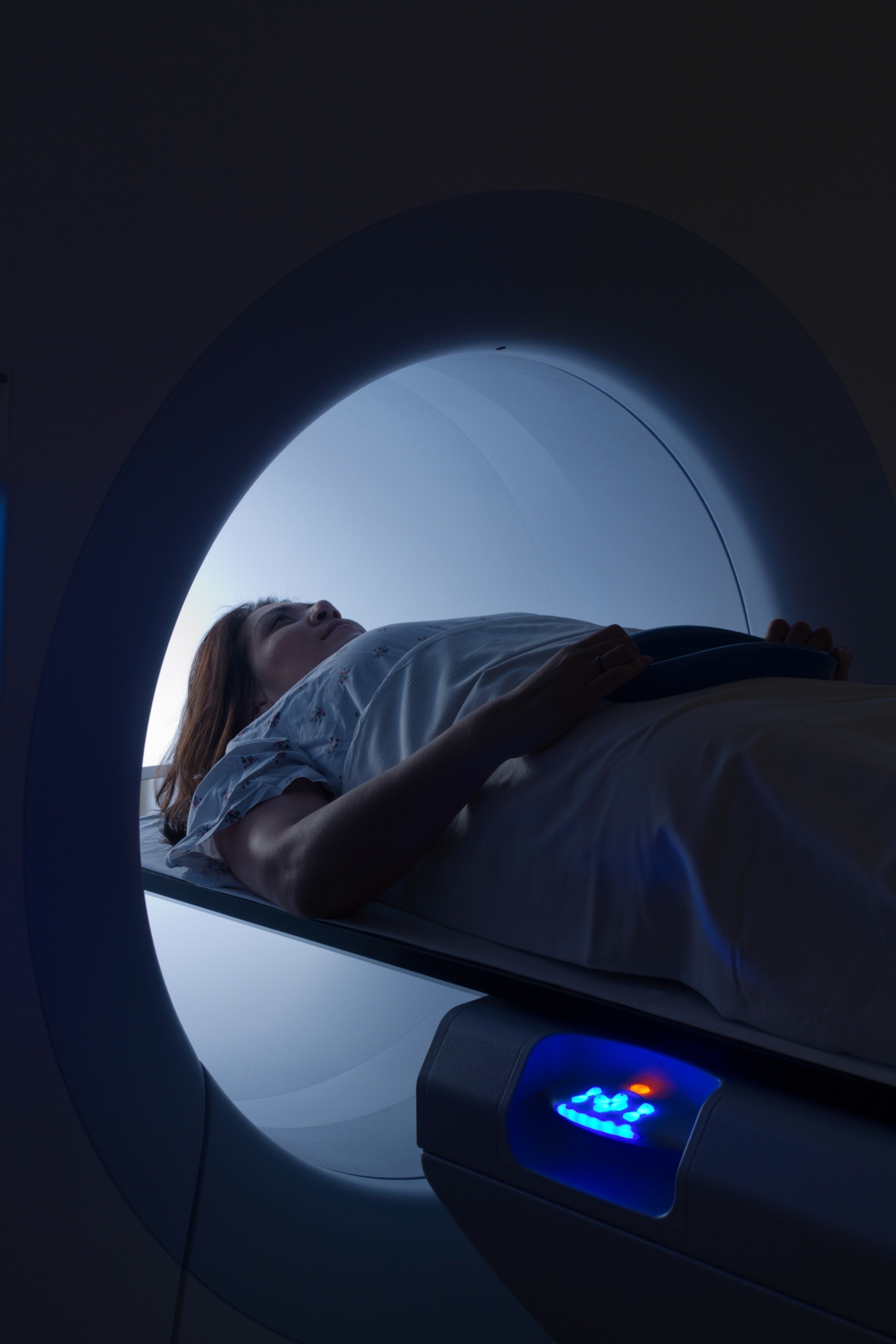 A close-up view of a woman laying on her back as she enters a MRI scanner.