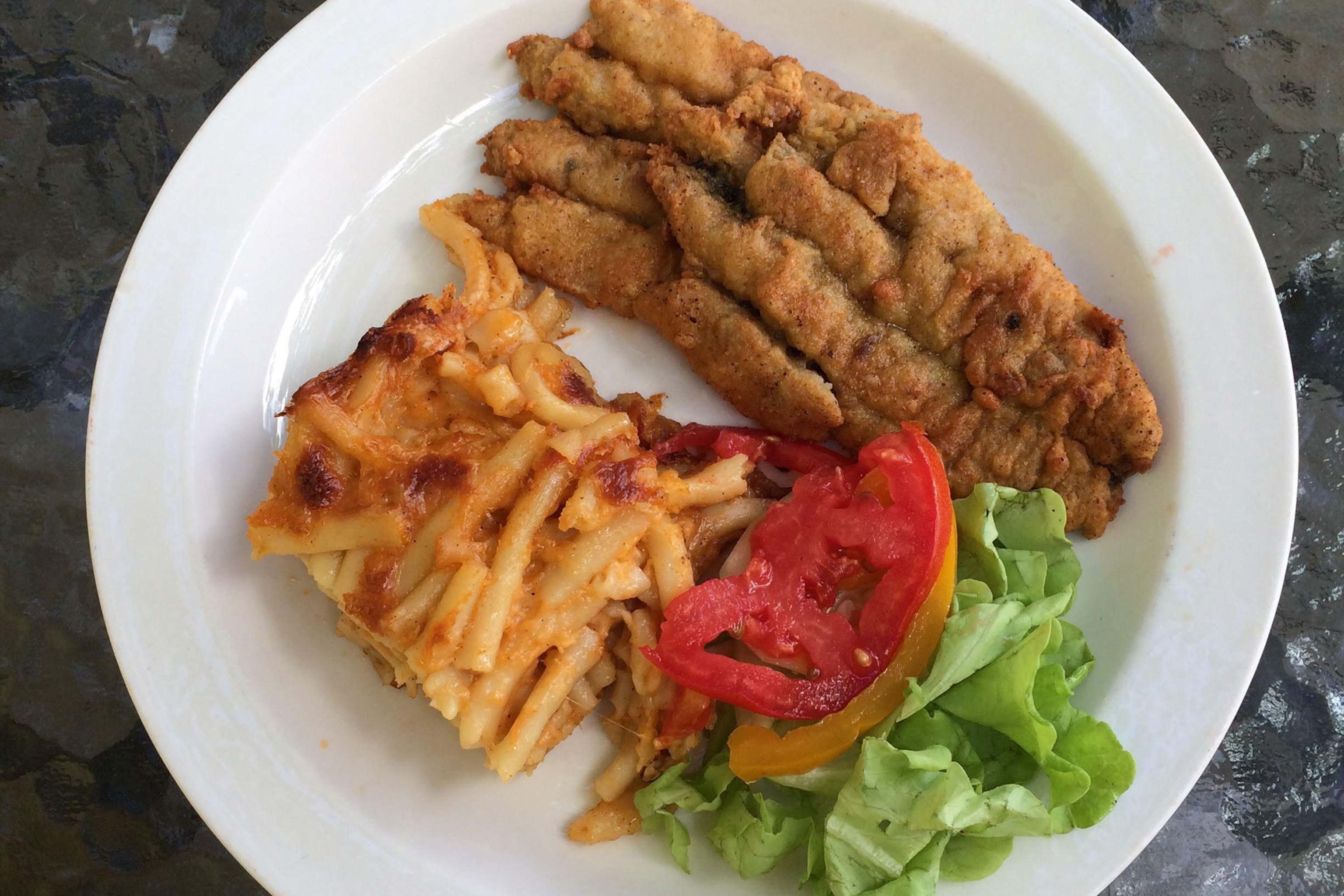 A plate of flying fish with macaroni pie and salad.