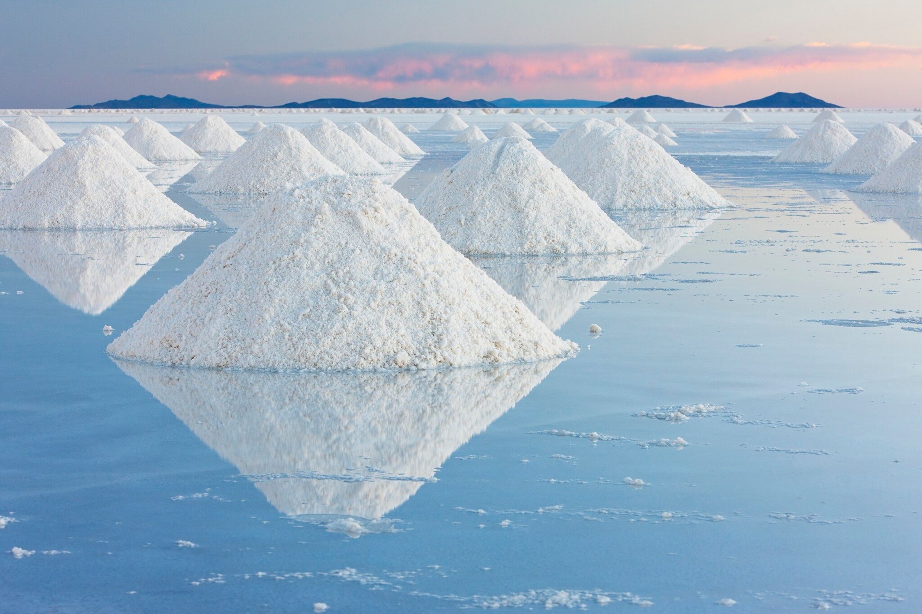 Hundreds of salt pans, small mounds that rise above a glassy floor.