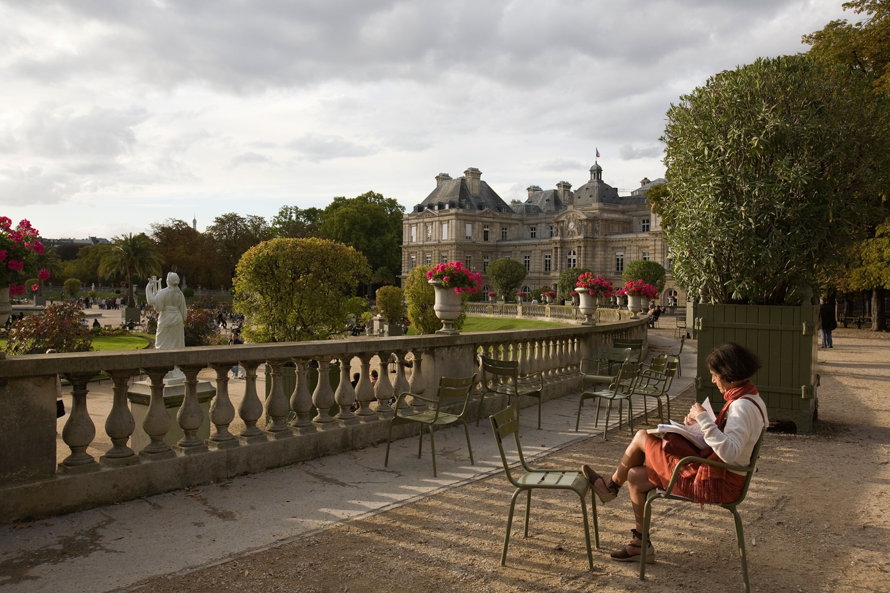 woman reading on a bench in the Jardin du Luxembourg.
