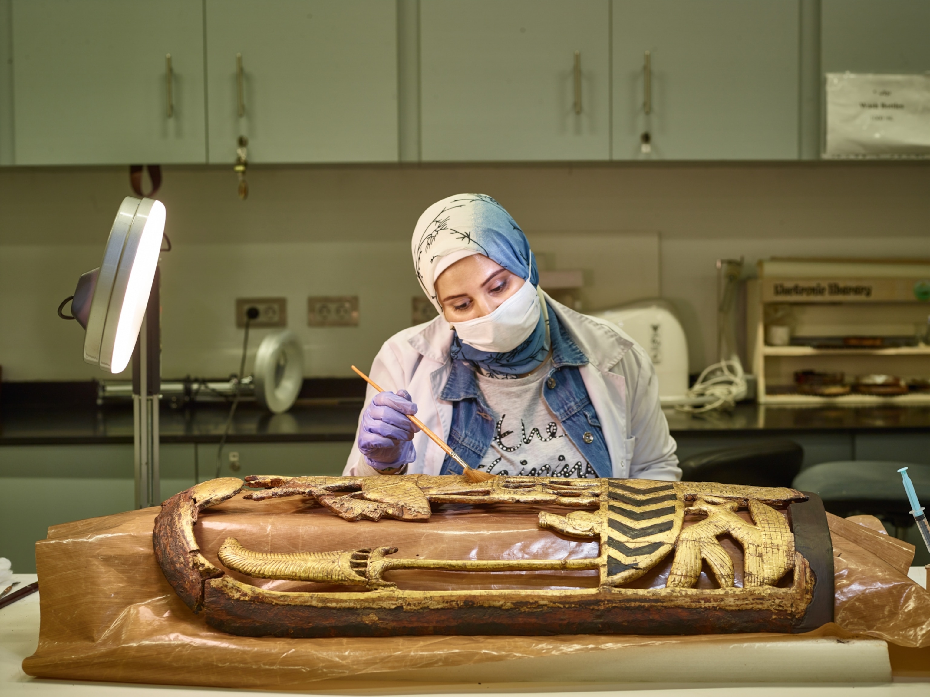 A team member at work on Tutankhamon’s shield inside the Wood Lab, Conservation Center at the Grand Egyptian Museum