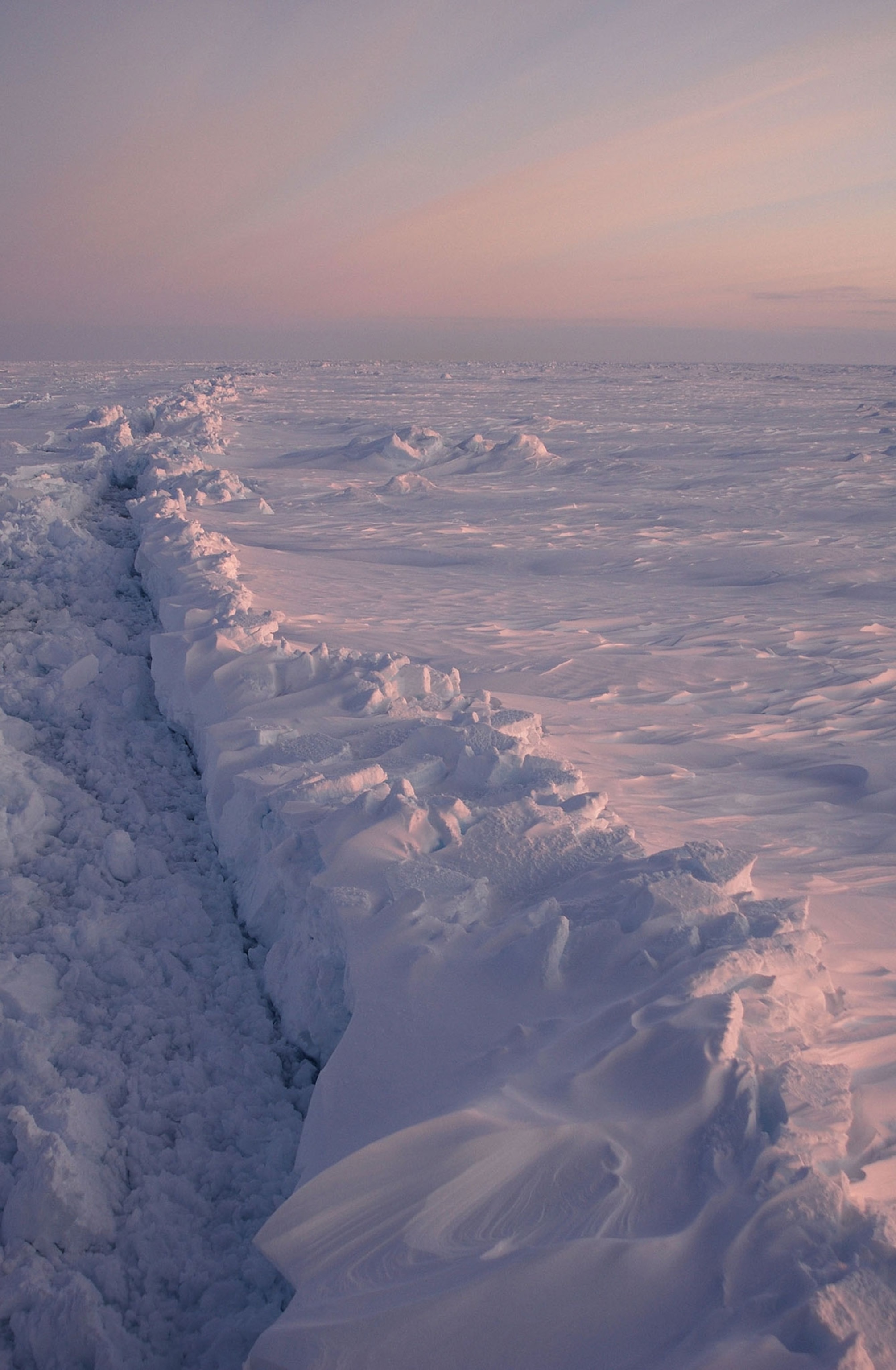 a pink and purple sunset over an iceshelf