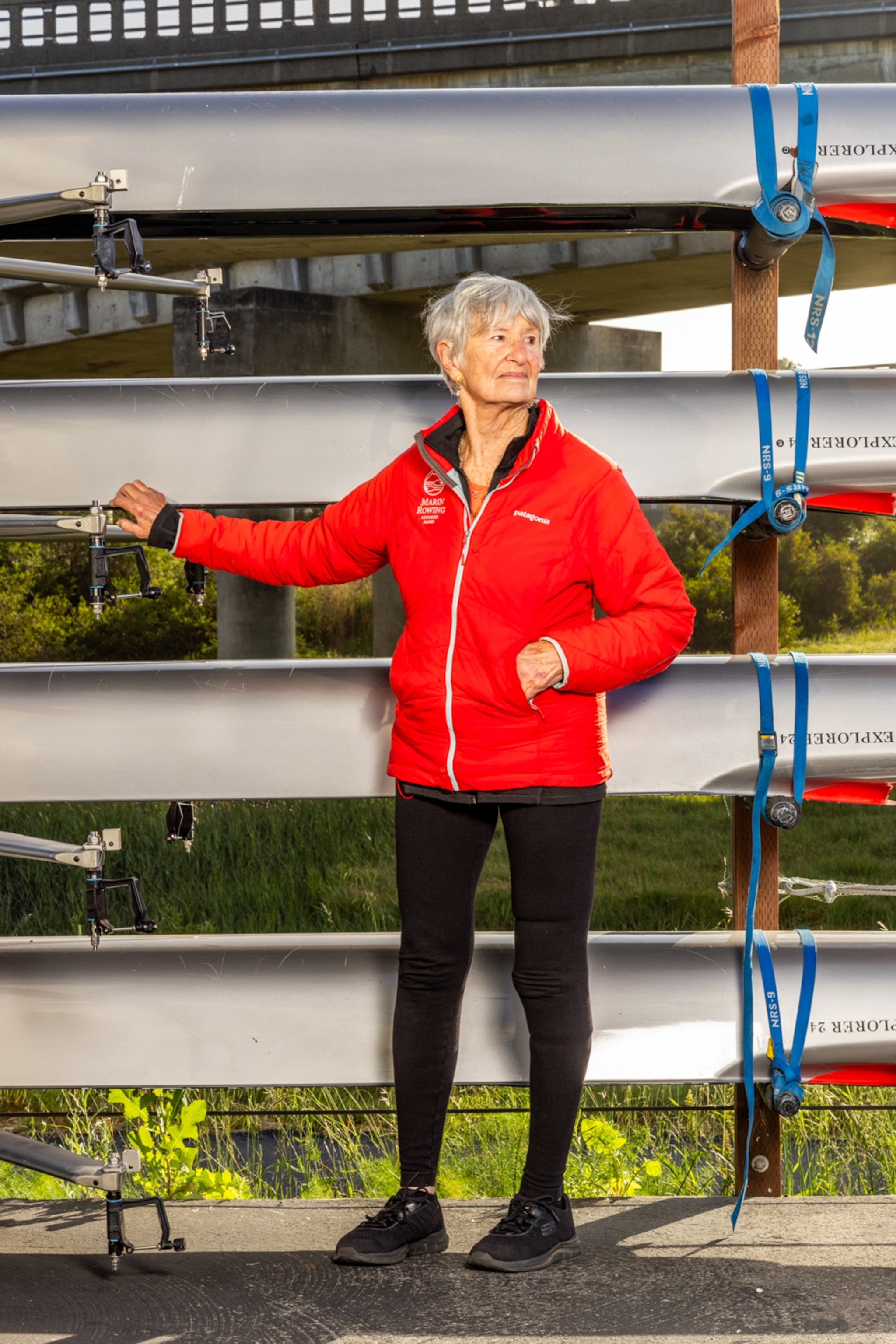A woman with short white hair and a red jacket.