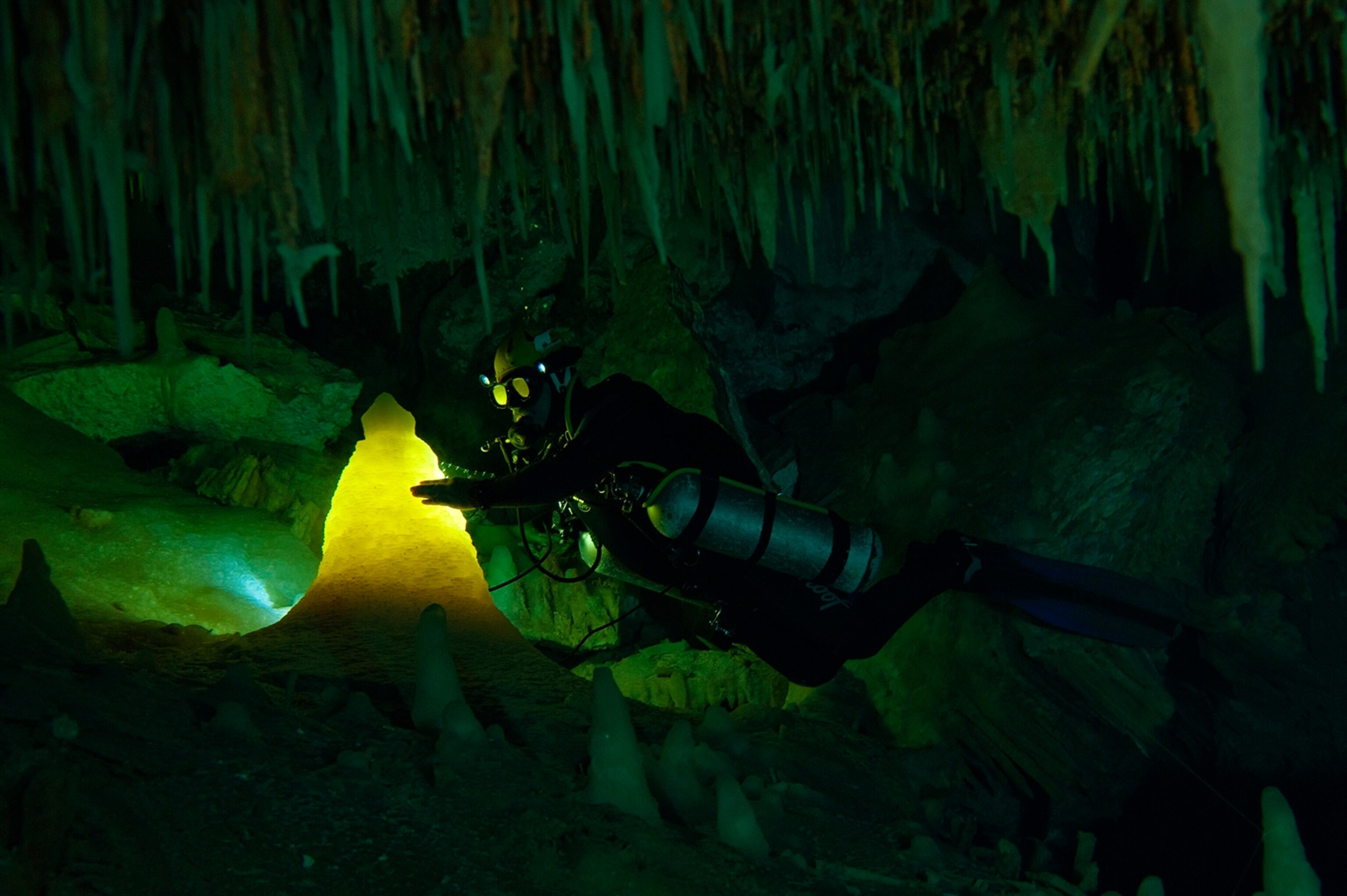 Brian Kakuk shining his dive light on a translucent stalagmite in Ralph's Cave