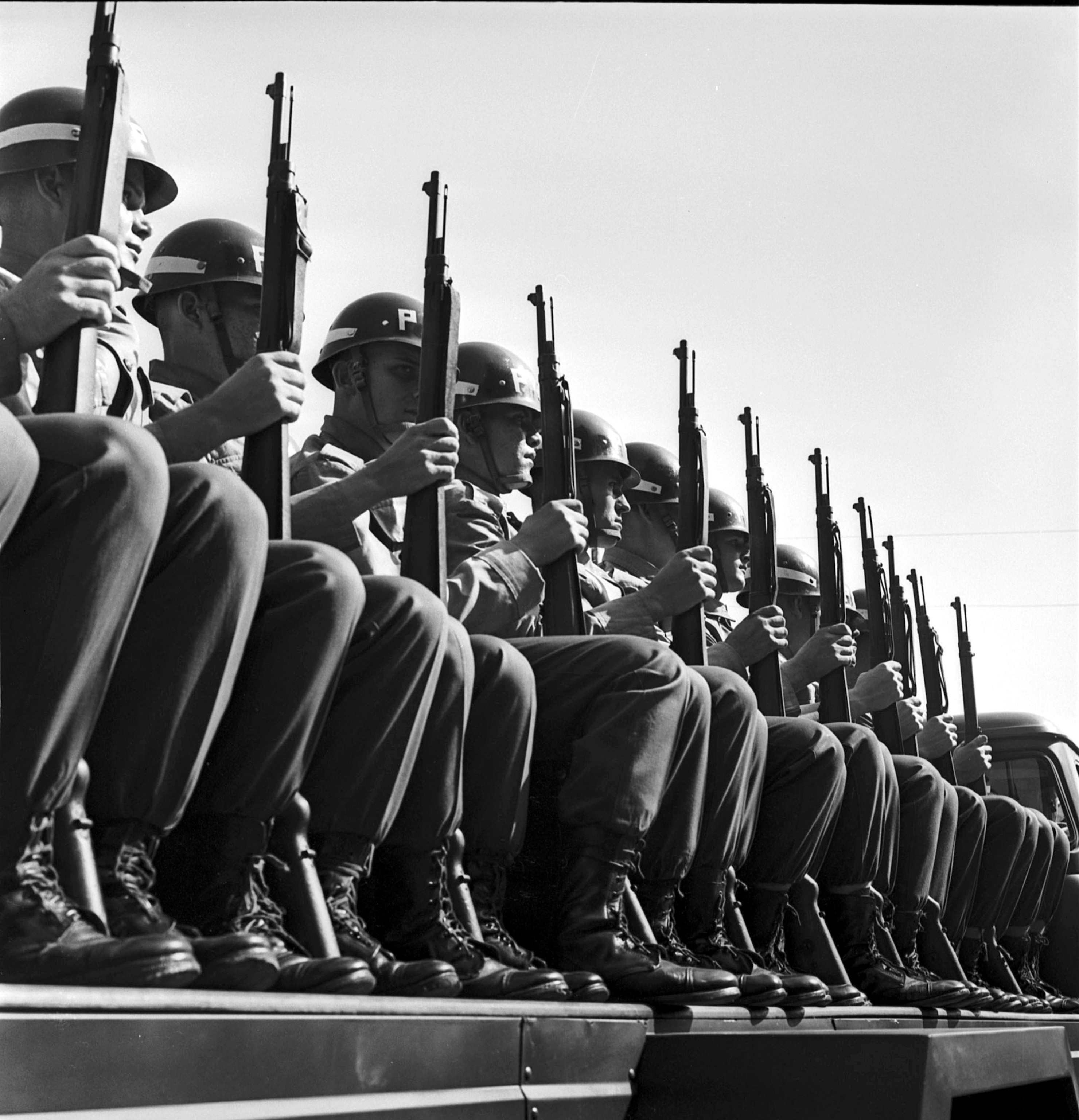 A black and white photograph of soldiers with guns and helmets.