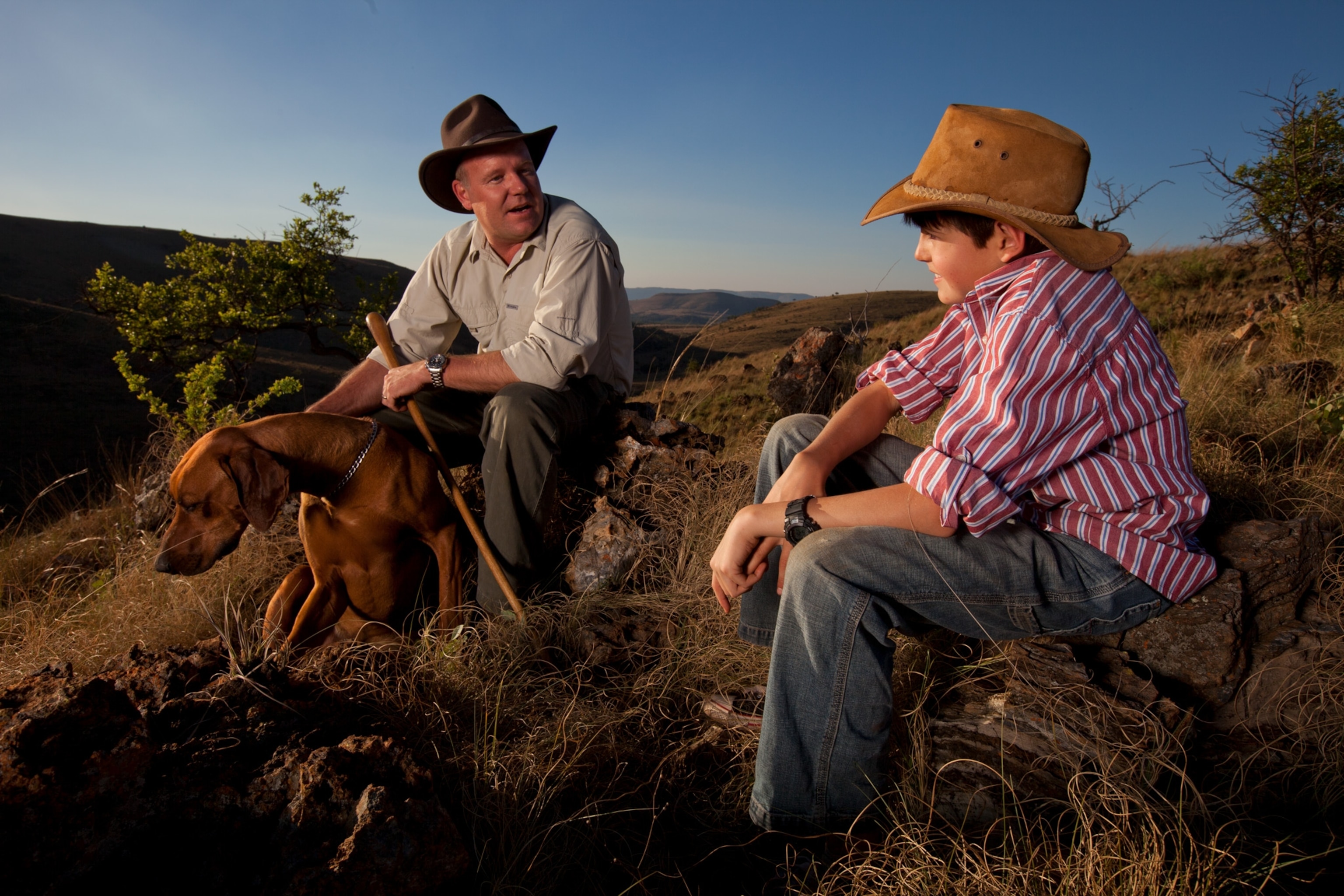 paleoanthropologist Lee Berger rests on a hill at the Malapa site, with his son