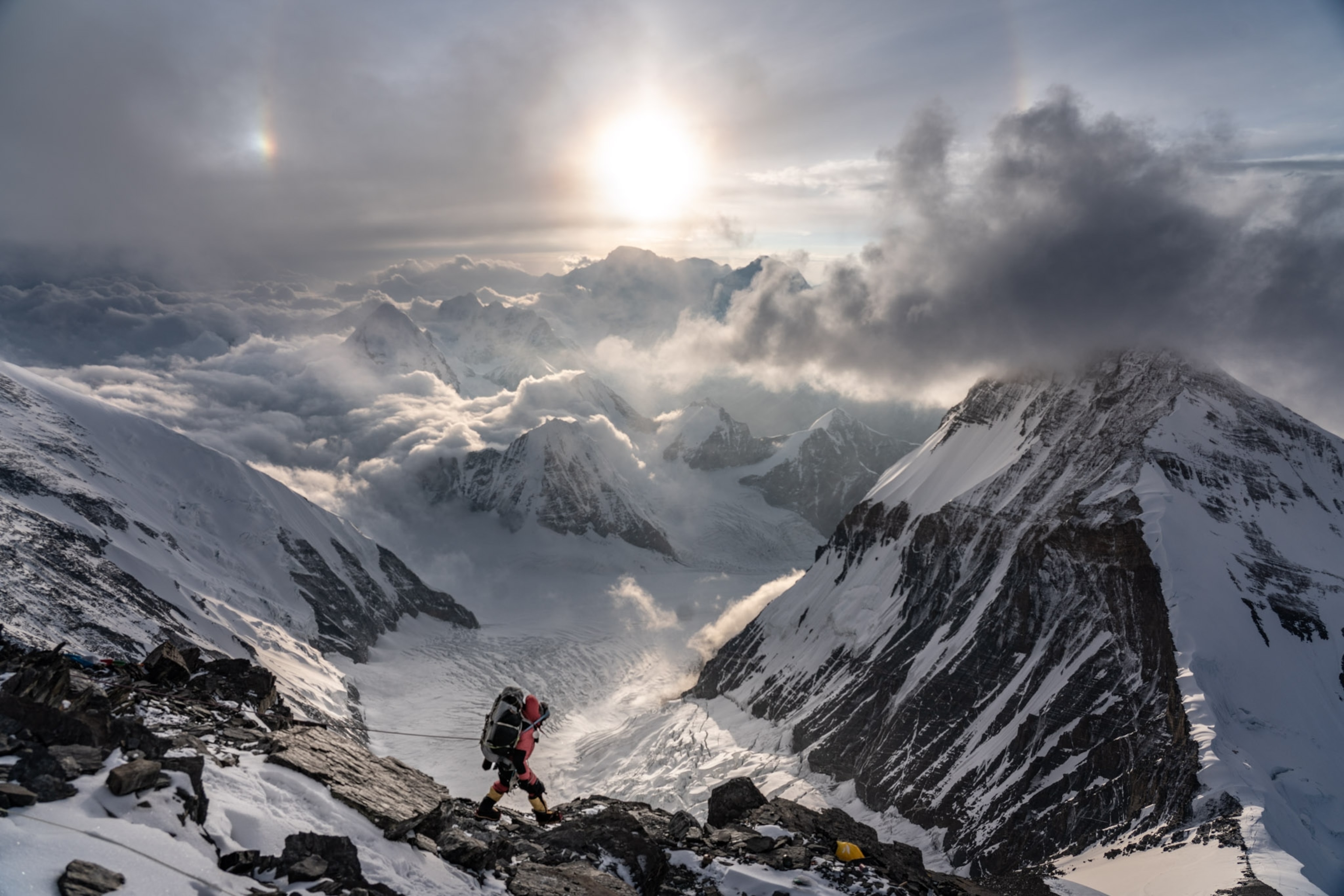 a man walking downward on a mountain between two peaks