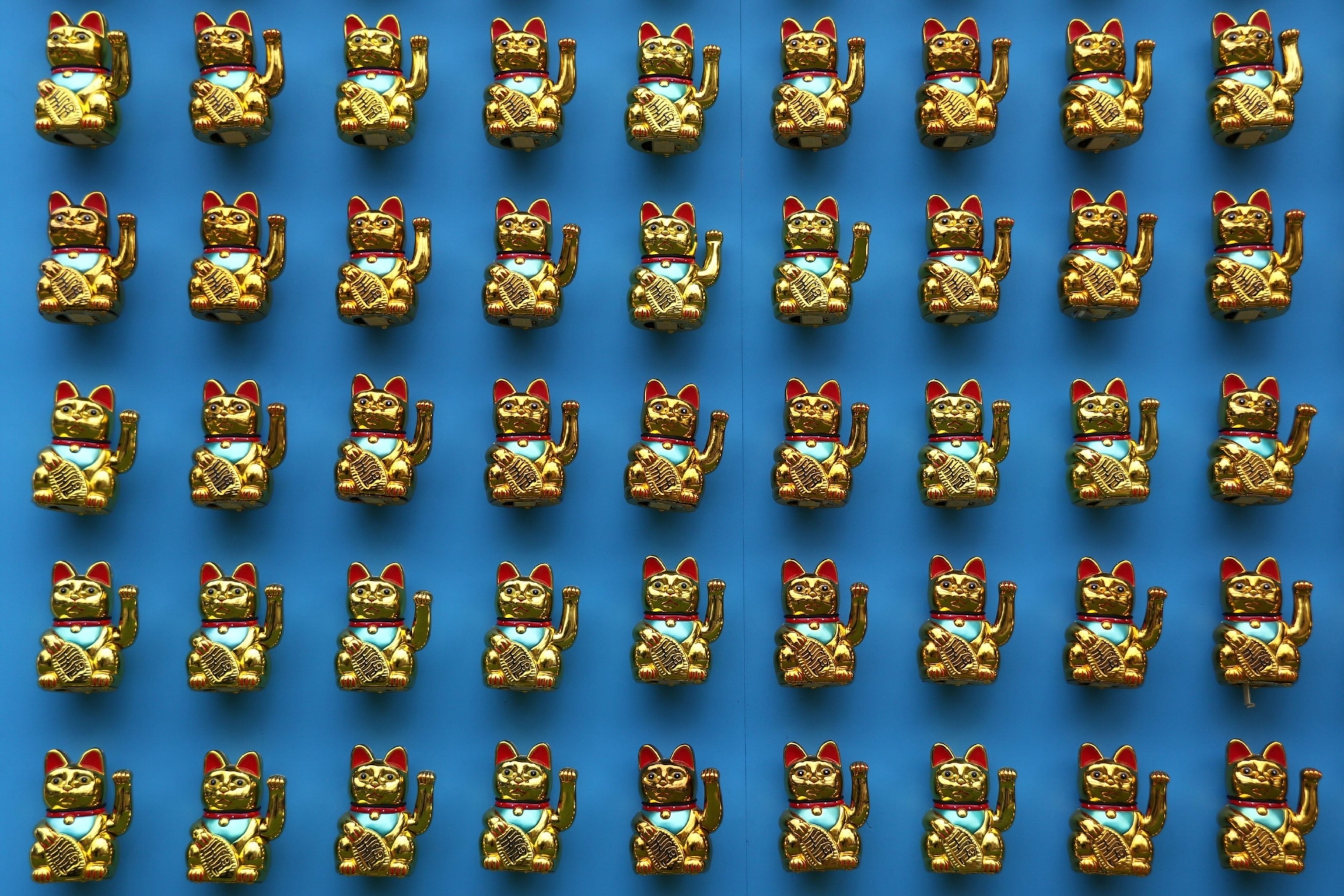 An abudance of cat figurines on a blue background