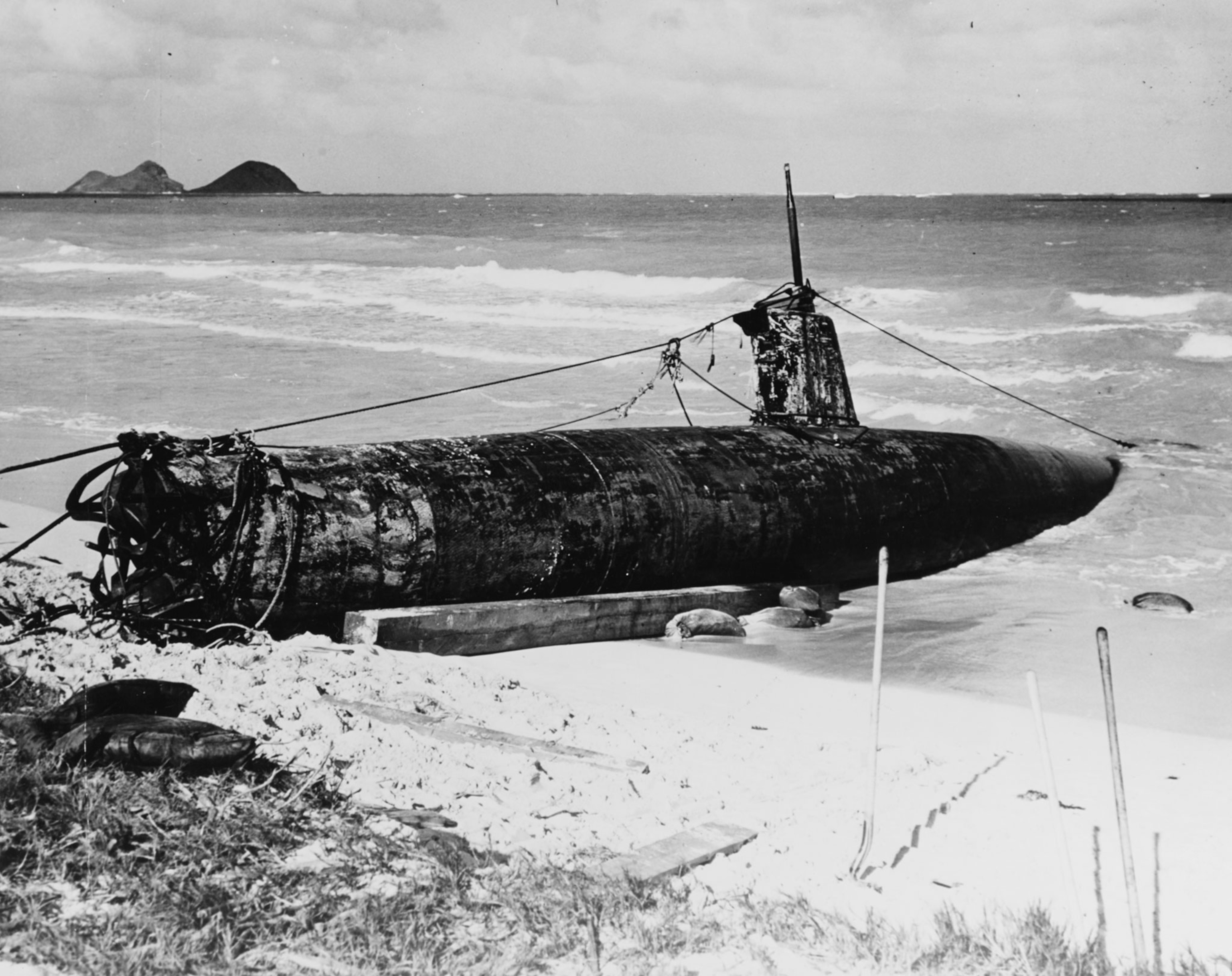 a black and white photo of a submarine beached in Oahu, Hawaii