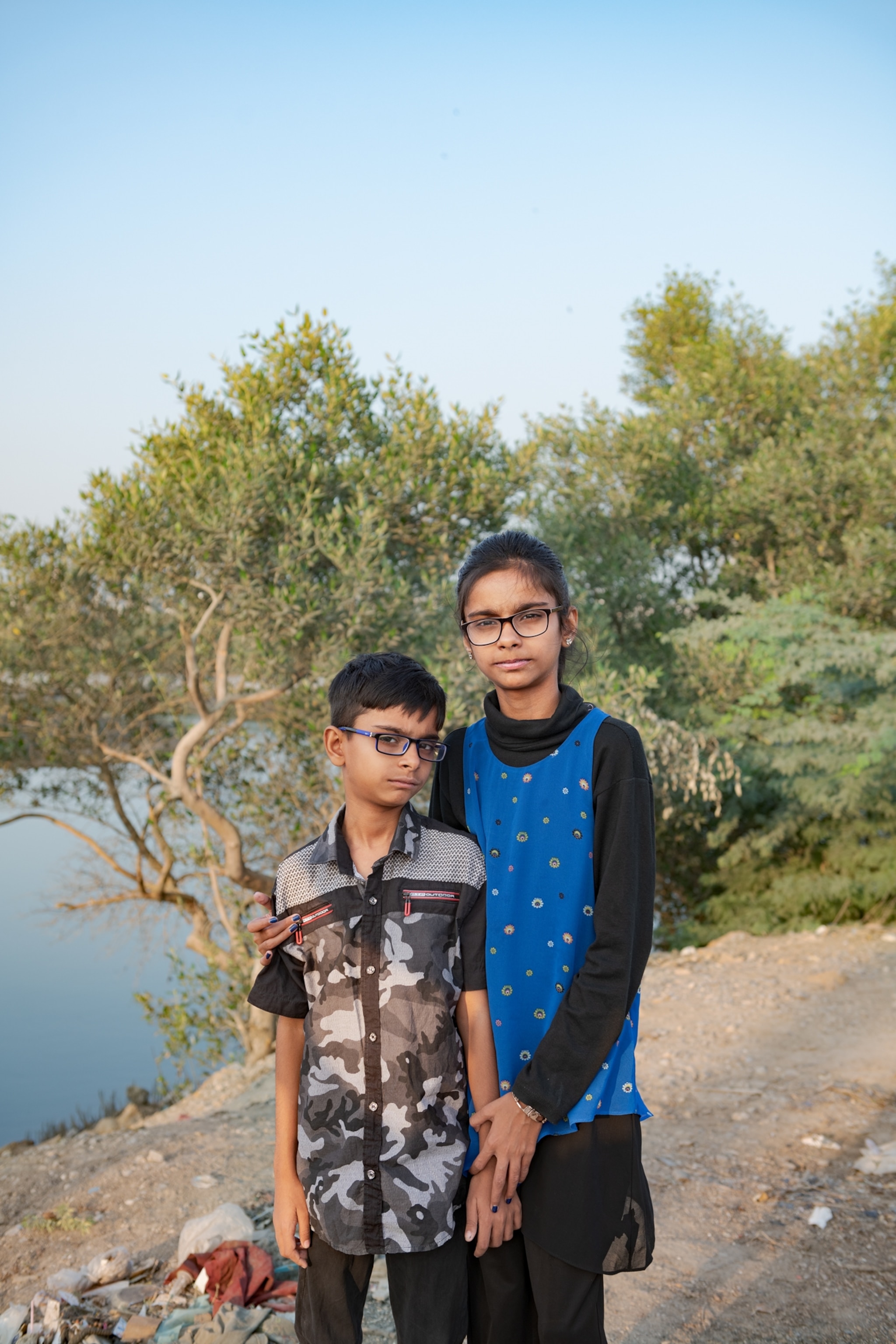 two young children on riverbank.