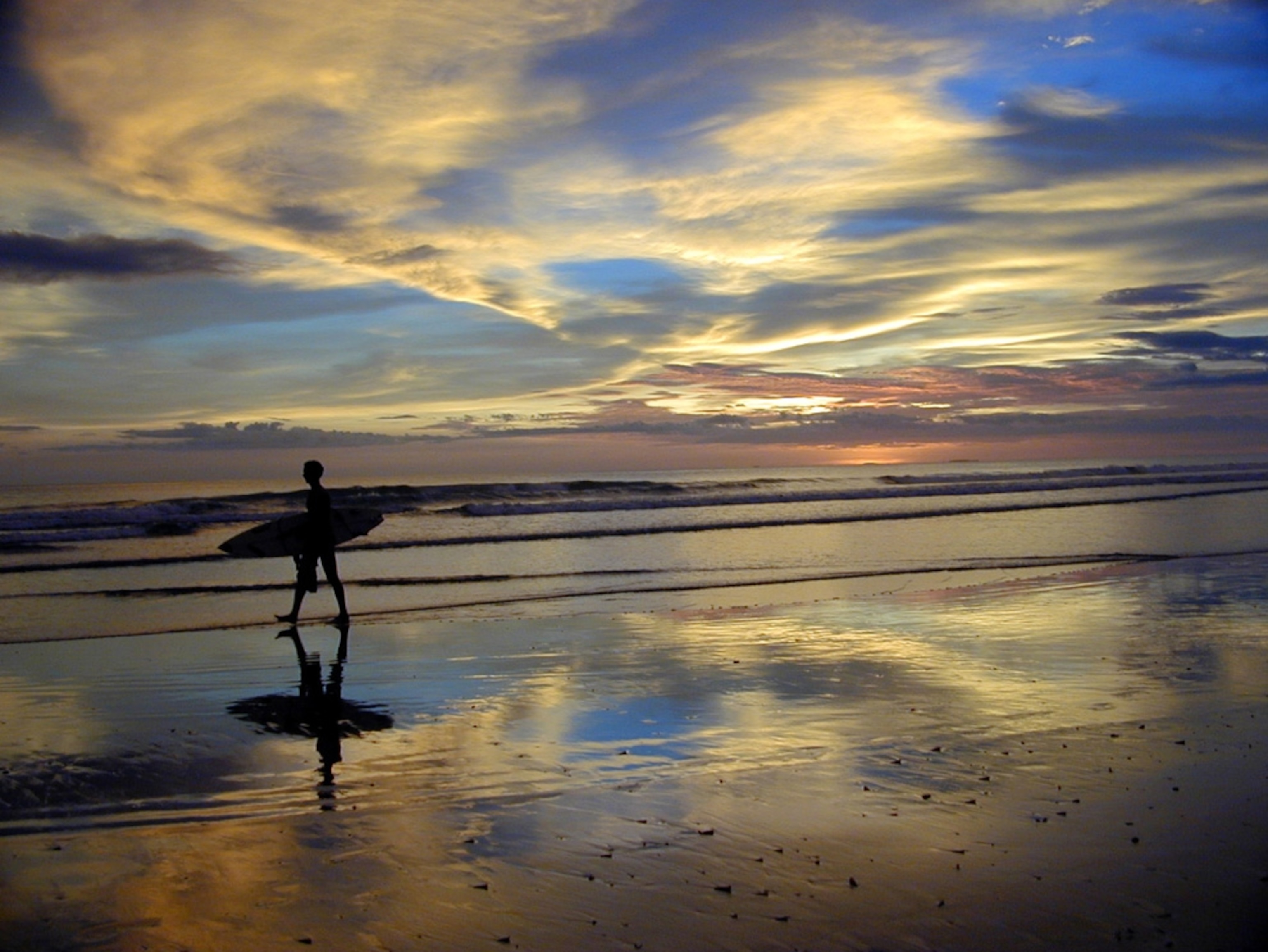 Surfer on a beach at sunset