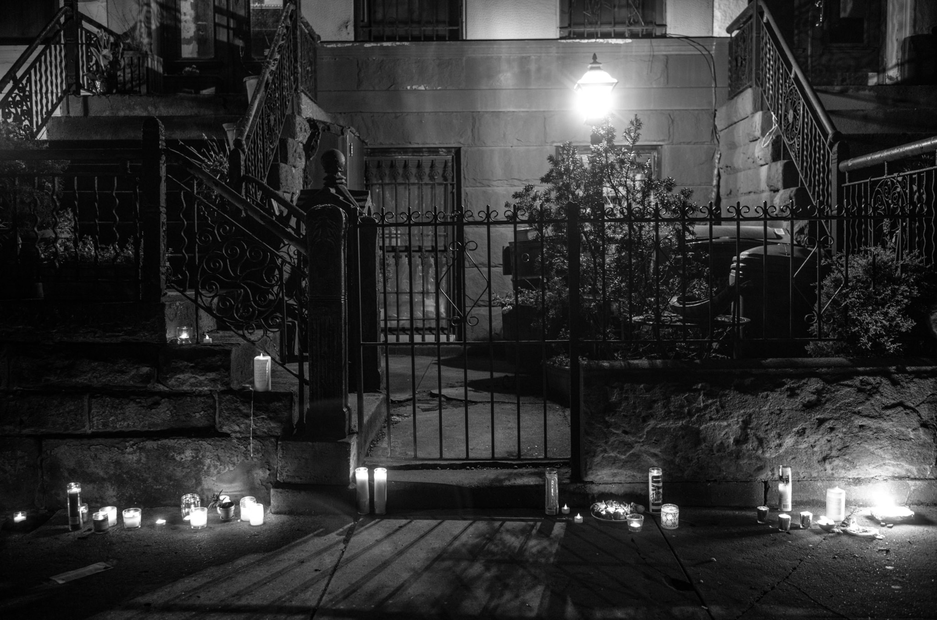 a dark street side lit by candles
