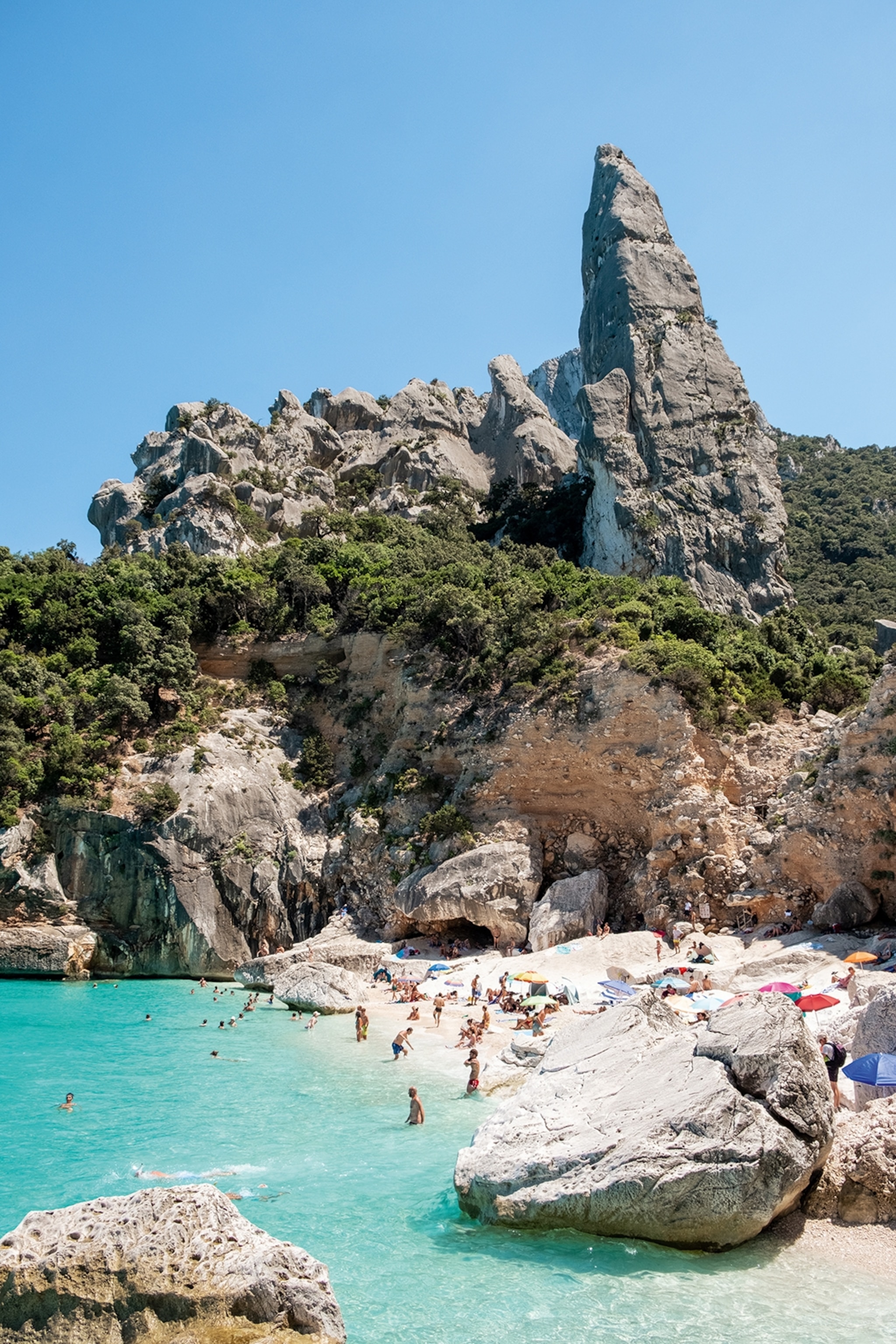 A busy beach set amongst cliffs.