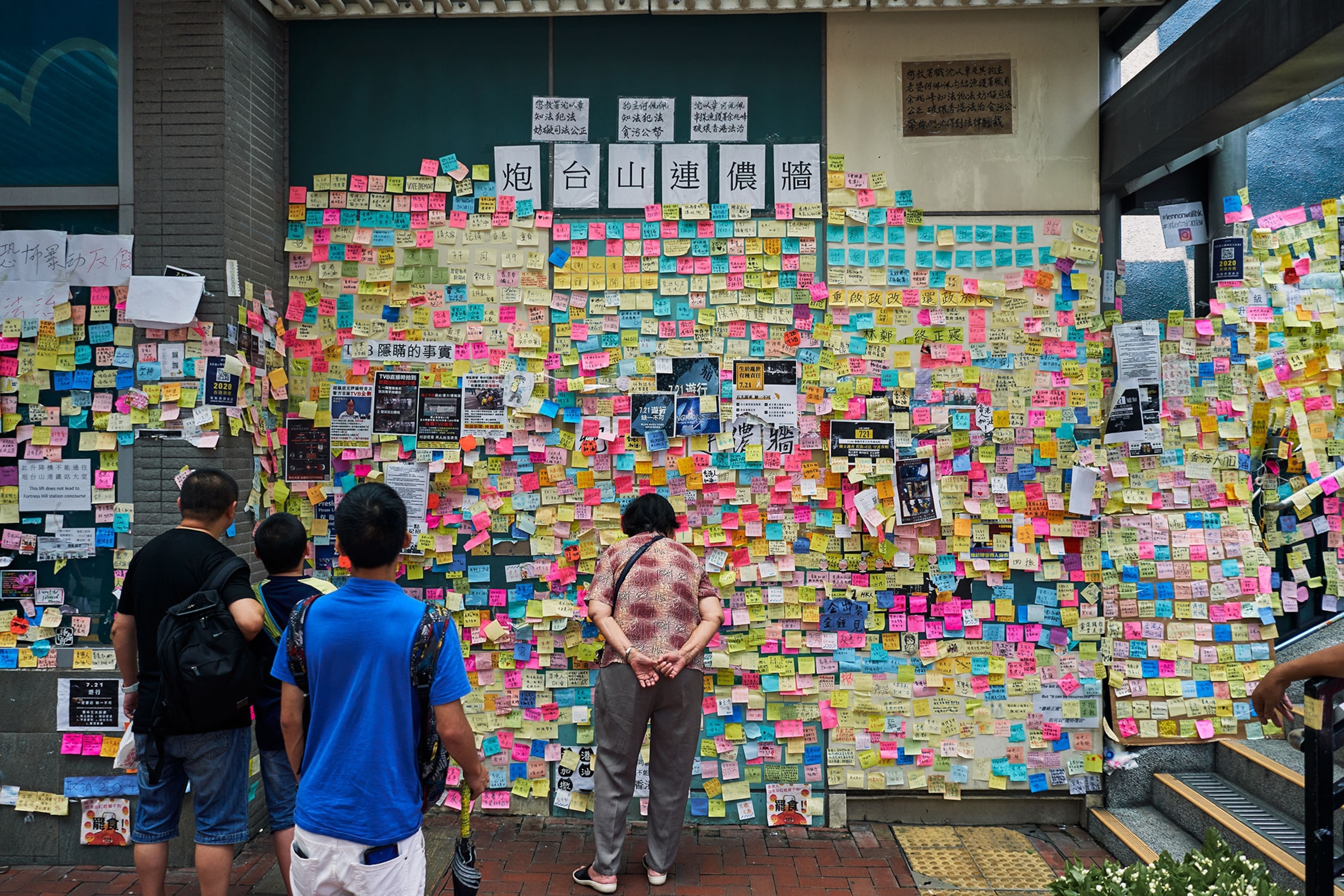 people looking at a lennon wall in Hong Kong