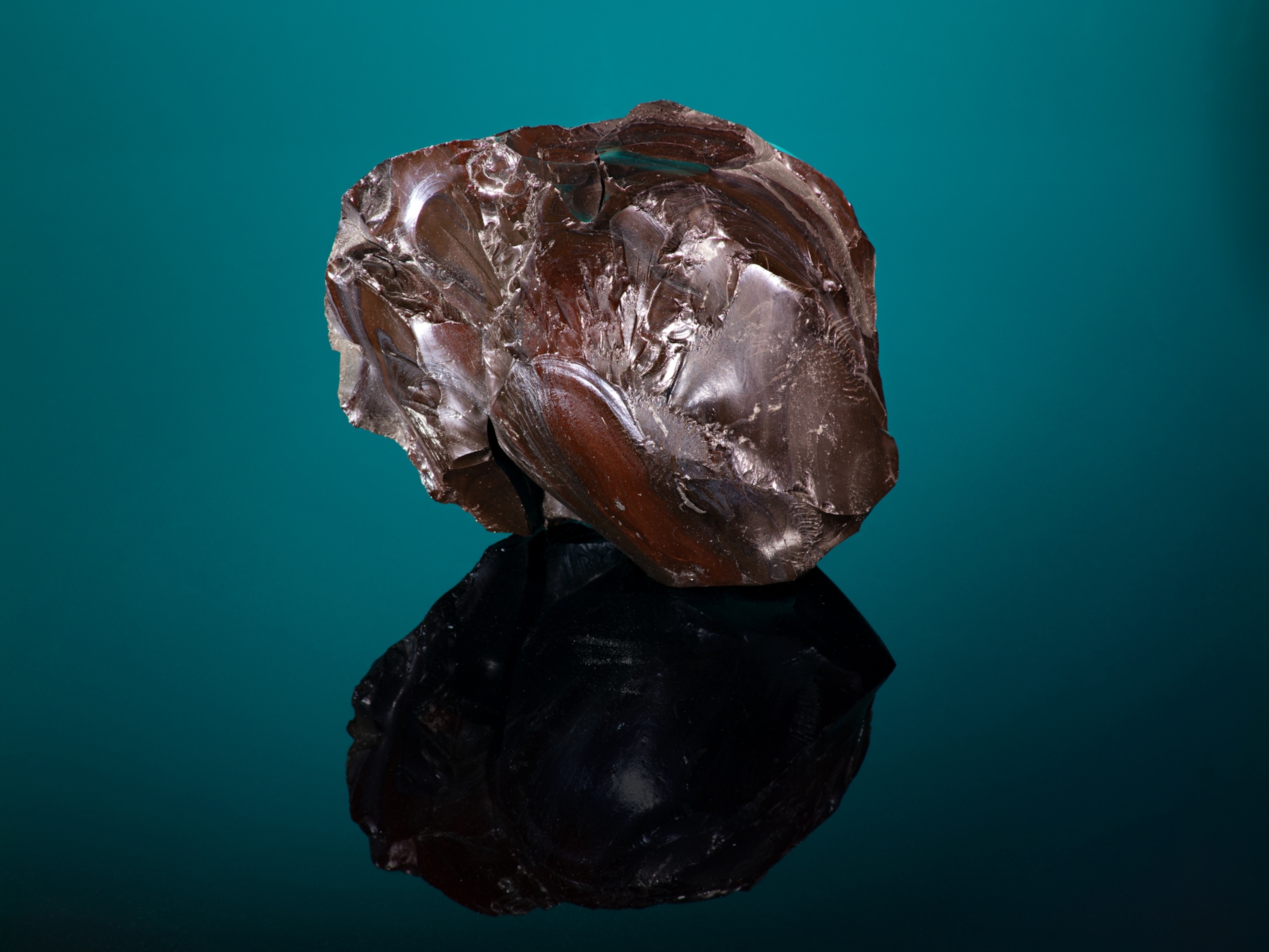 A Coca Cola-colored chunk of glass sits in a studio setting.