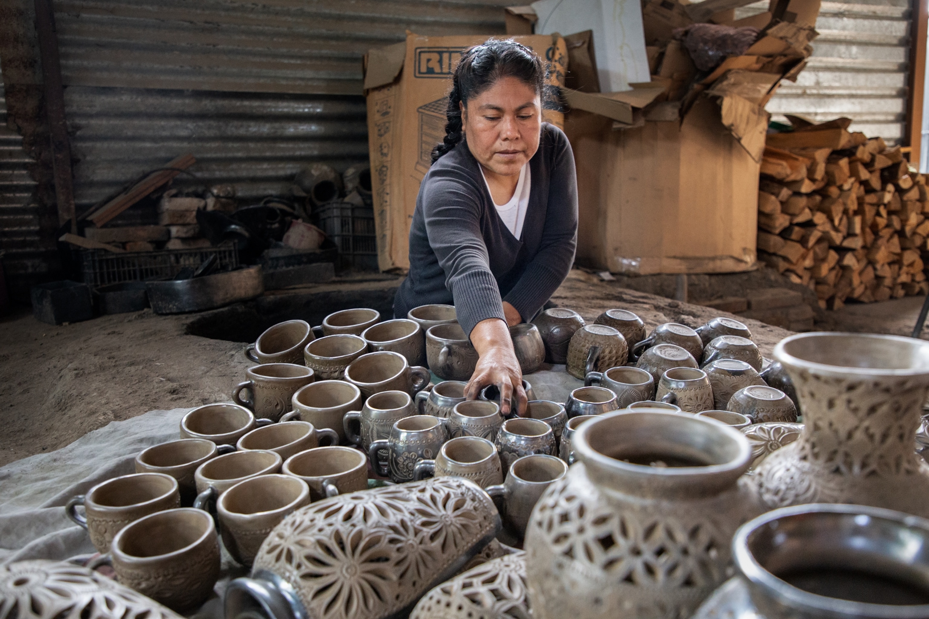 Graciela Simon López placing the pottery pieces in a stone and adobe kiln in a space in her hom