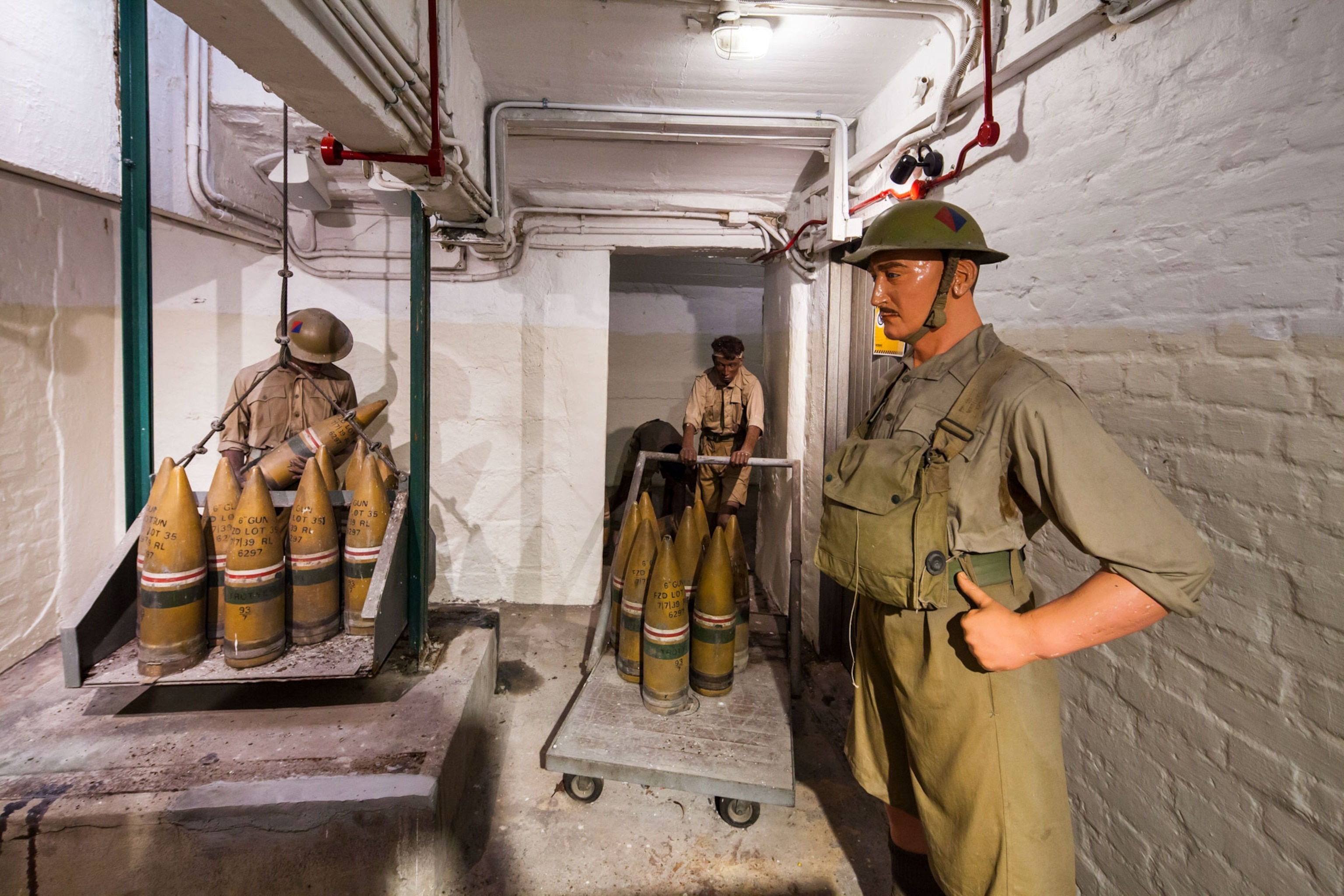 three dummies dressed as British soldiers moving and loading ammunition in a display in Singapore