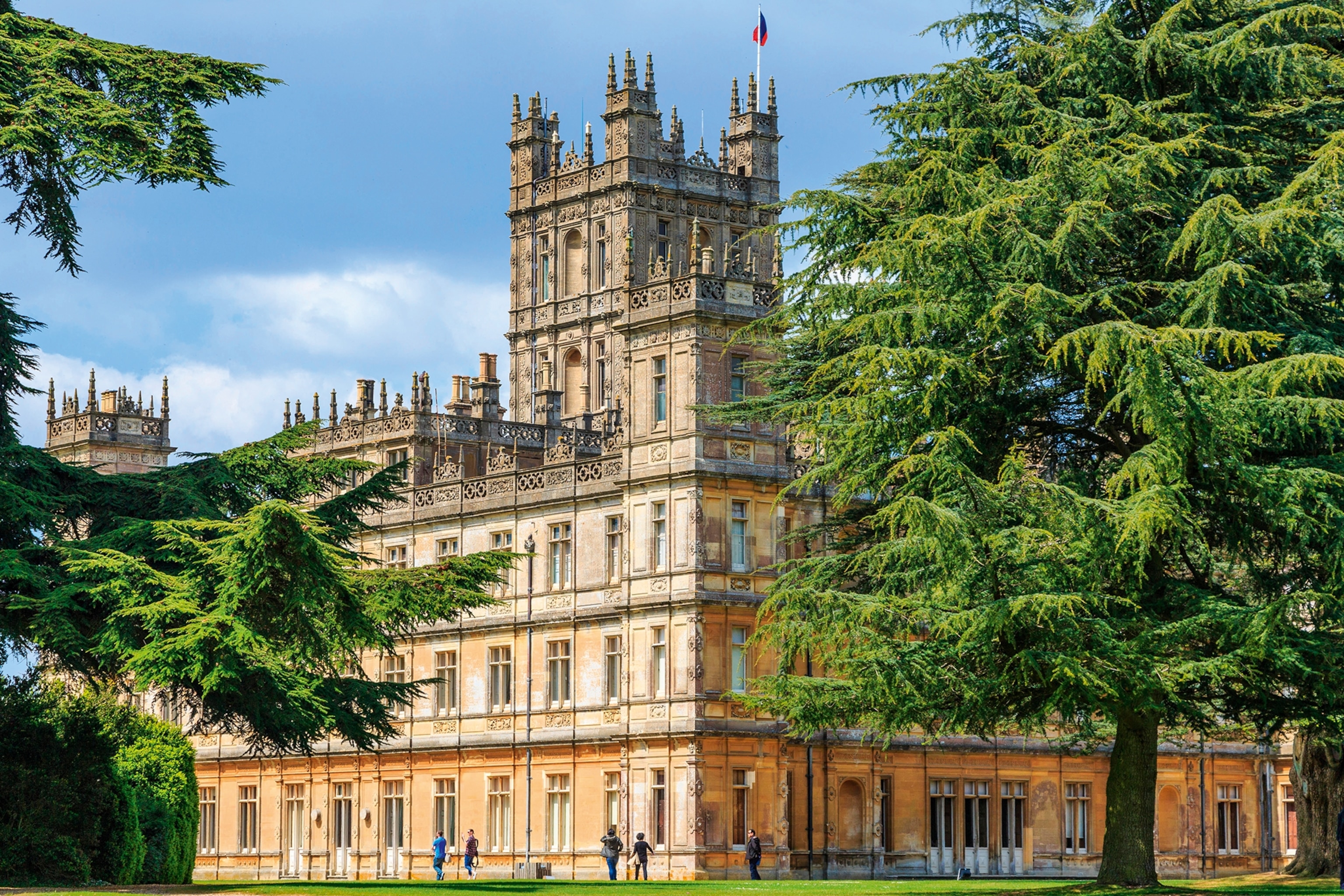 A decorative traditional English building in a green park.